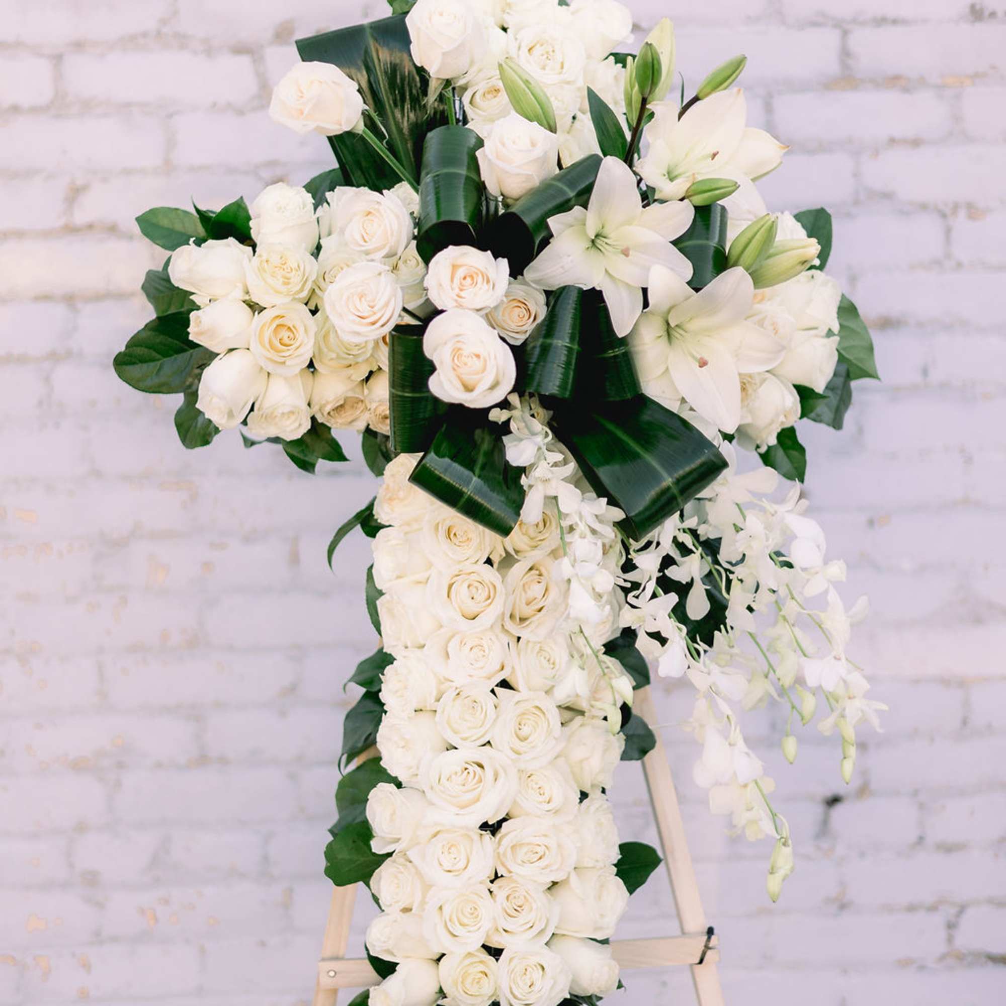 Easel stand cross-shaped spray. Mix of fresh flowers with textures and greens.
Mounted