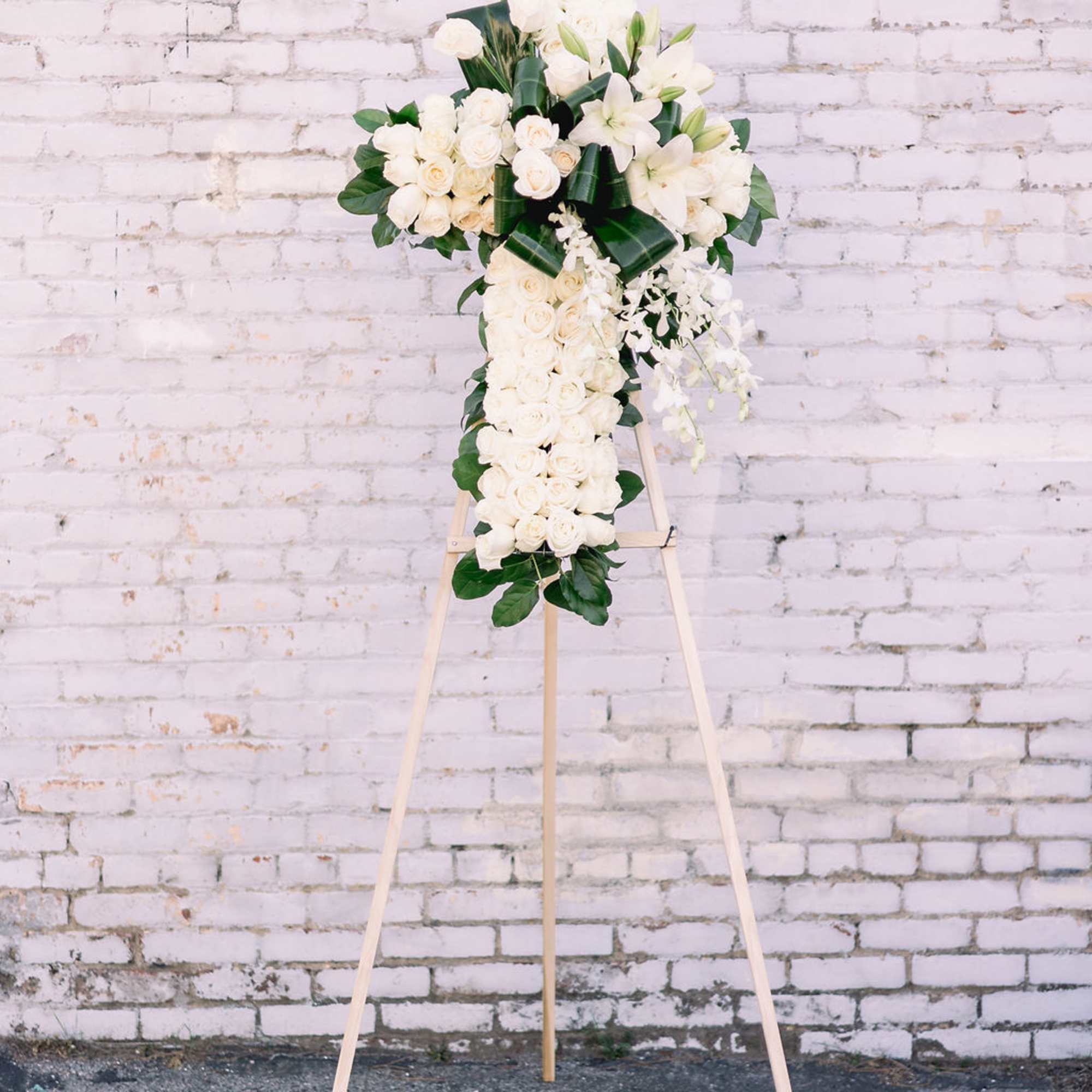 Easel stand cross-shaped spray. Mix of fresh flowers with textures and greens.
Mounted