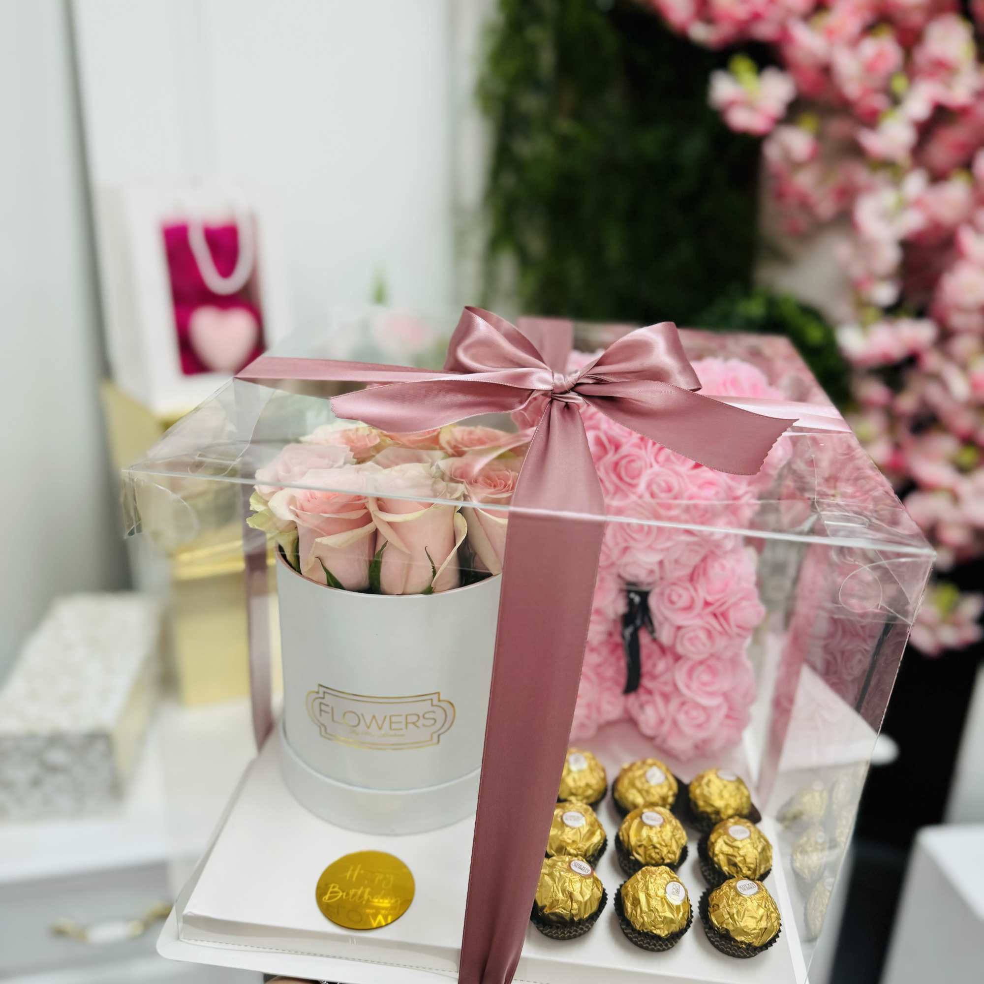 Pink roses in a gift box with chocolates under a clear cover