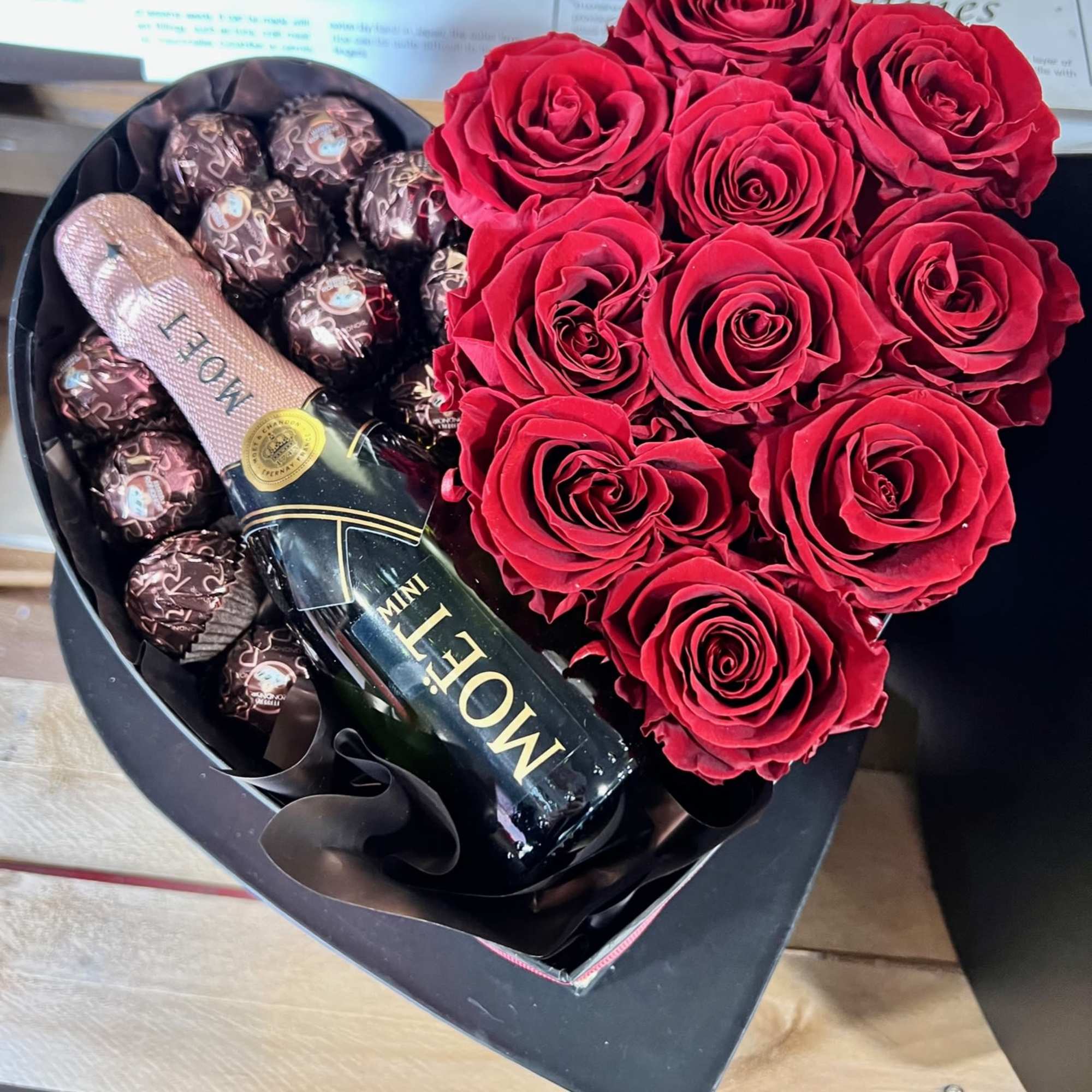 Heart-shaped box with red roses, chocolates, and a mini Moet bottle