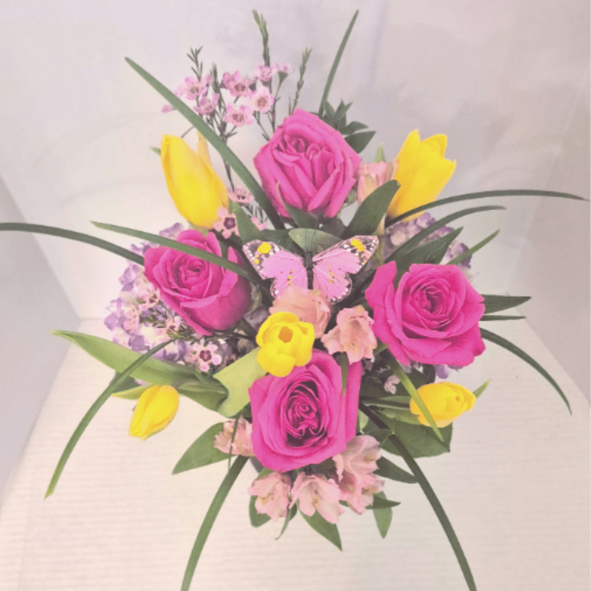 A bright mix of tulips, roses, alstromeria and grasses in a purple