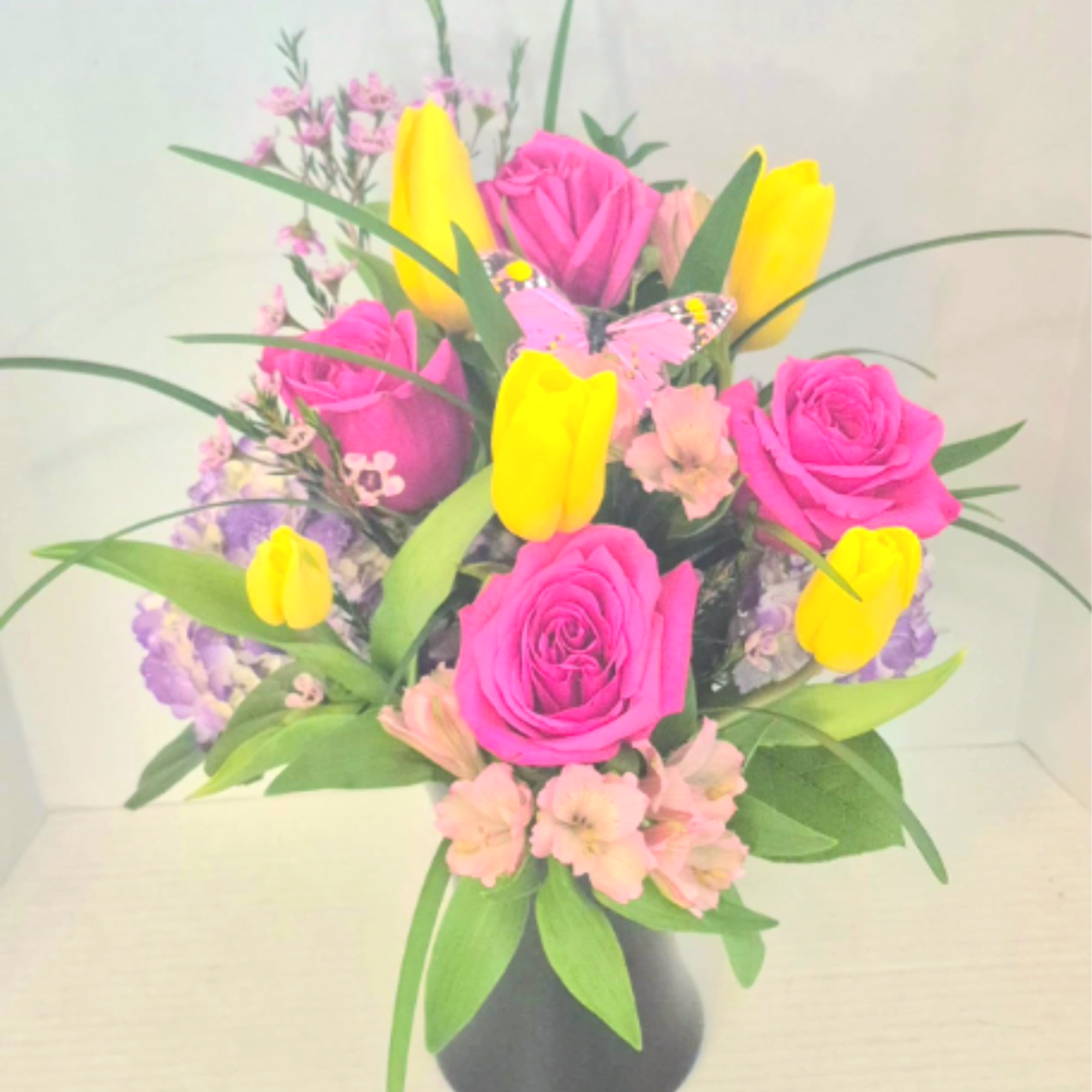 A bright mix of tulips, roses, alstromeria and grasses in a purple