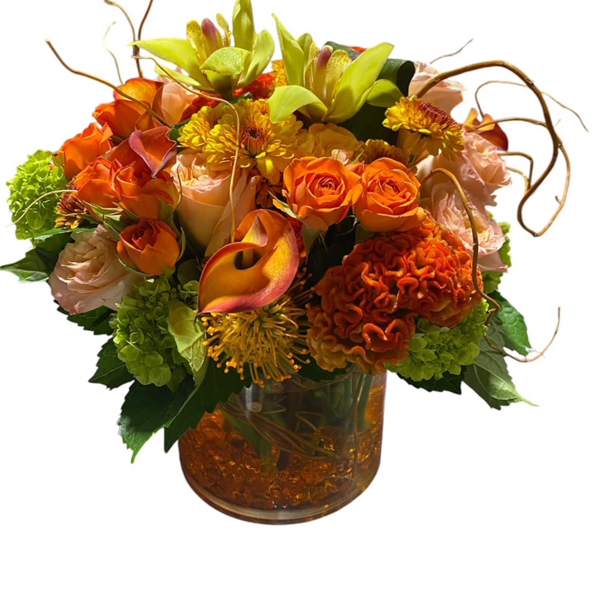 Orange and peach floral arrangement in a glass vase