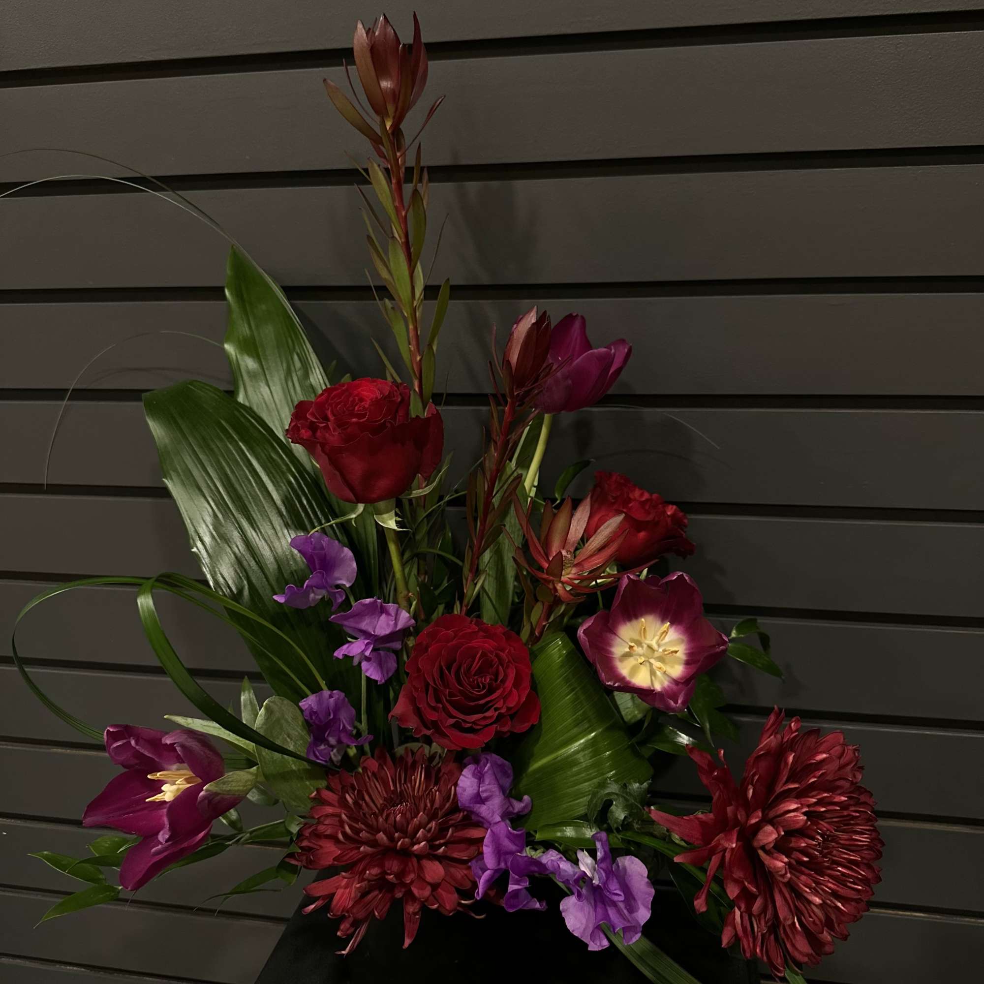  A captivating arrangement that embraces deep, moody elegance with a bit