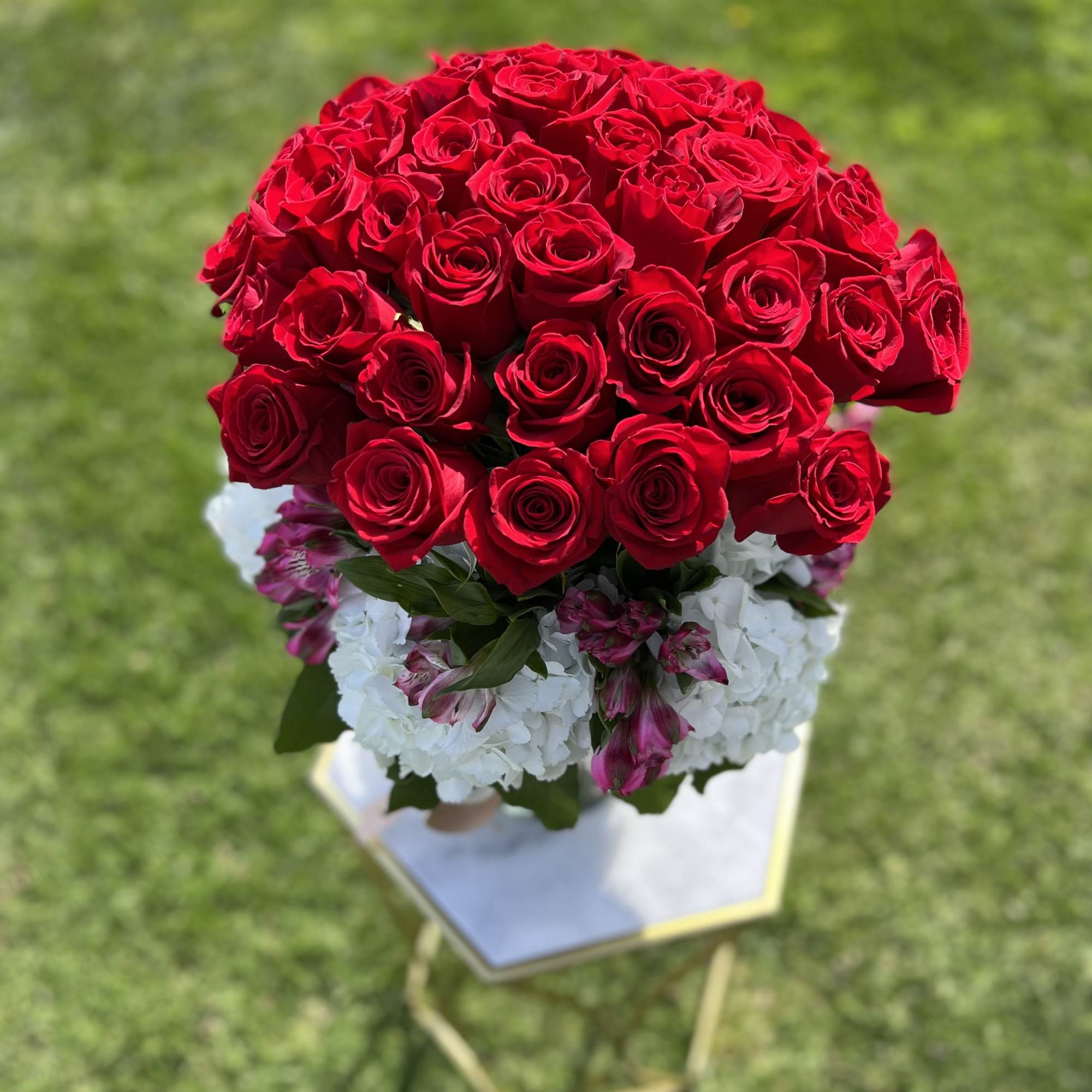Bouquet of red roses with white and pink flowers on a stand