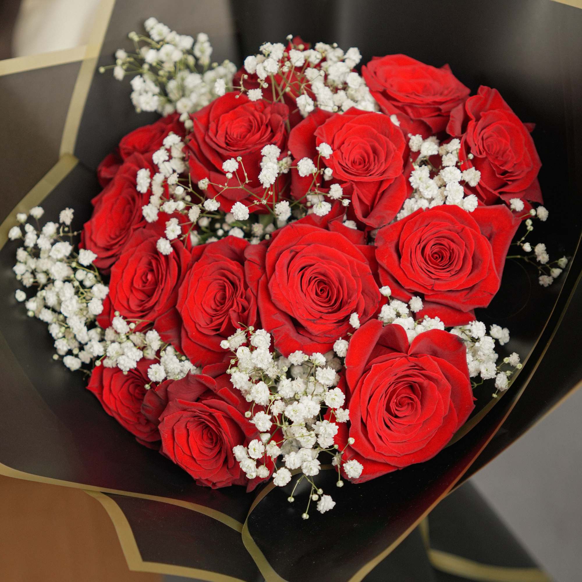 Striking bouquet featuring 12 premium red roses, imported from Ecuador, wrapped in
