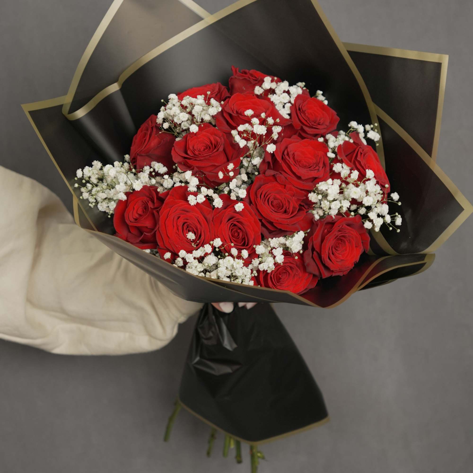 Striking bouquet featuring 12 premium red roses, imported from Ecuador, wrapped in