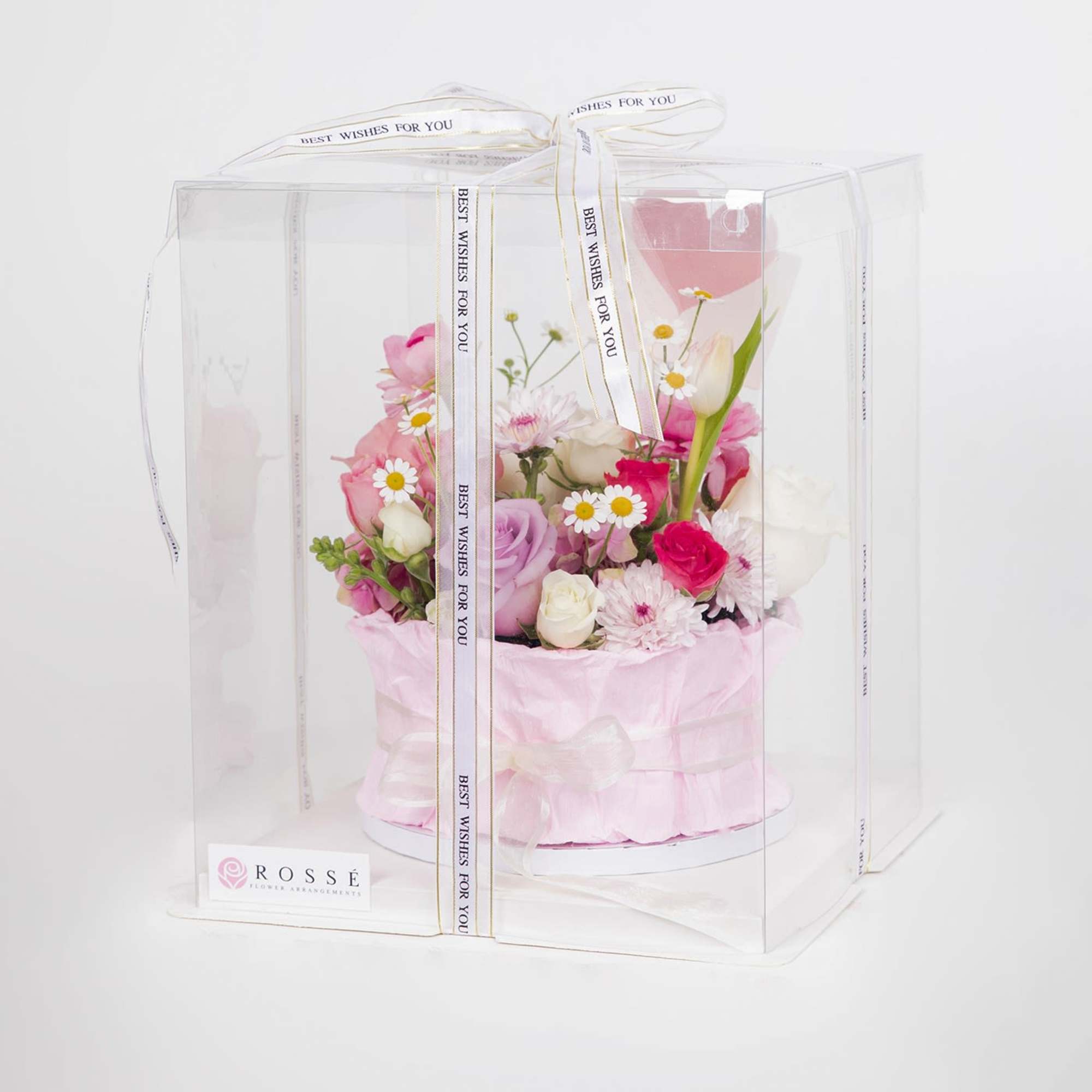 A cake-inspired floral design featuring roses and seasonal blooms in soft pink