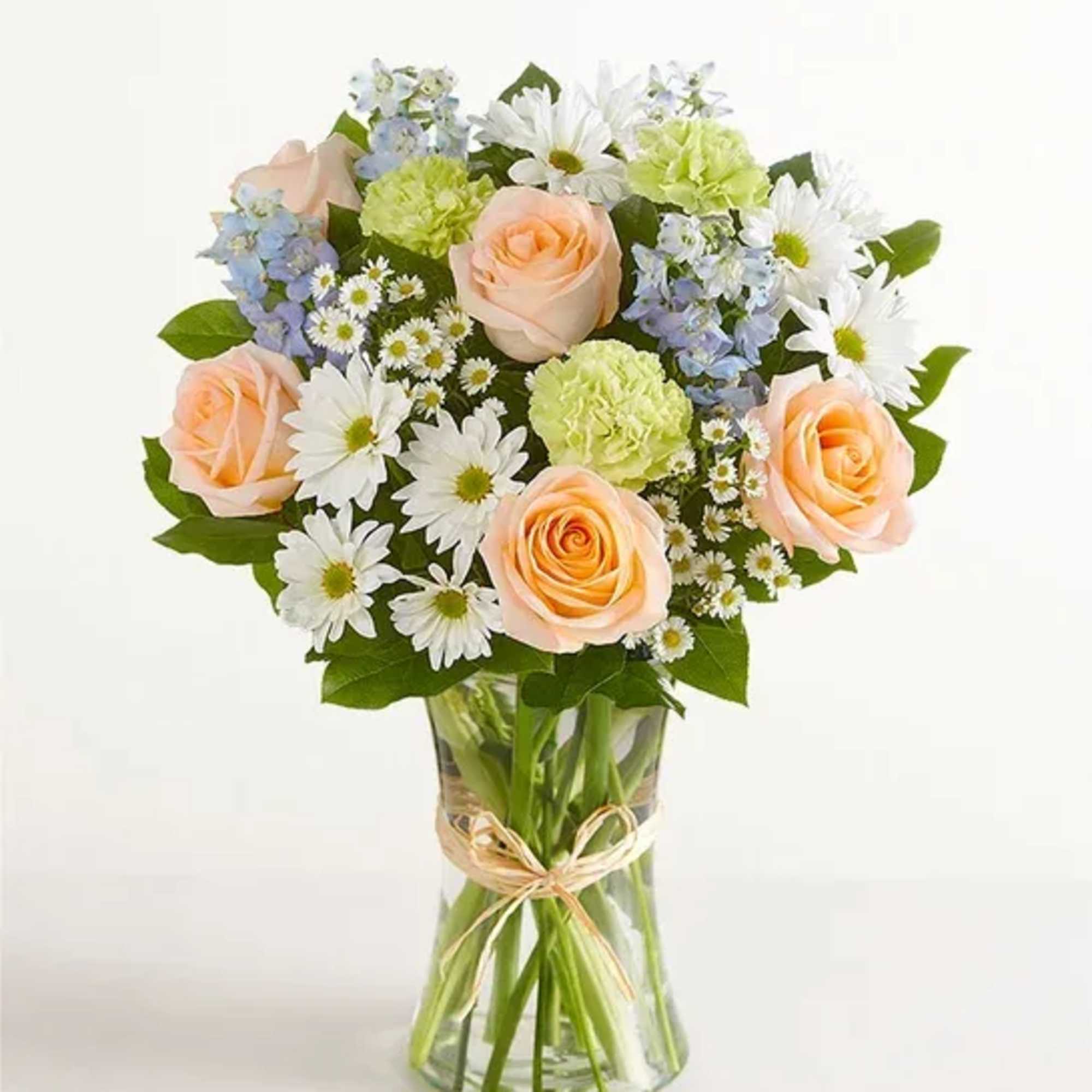 Bouquet of peach roses, white daisies, and blue flowers in a glass vase