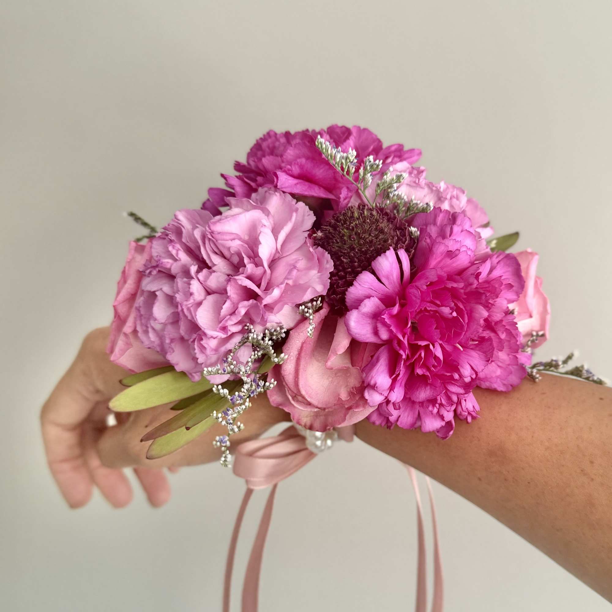 Pink floral wrist corsage with ribbon ties