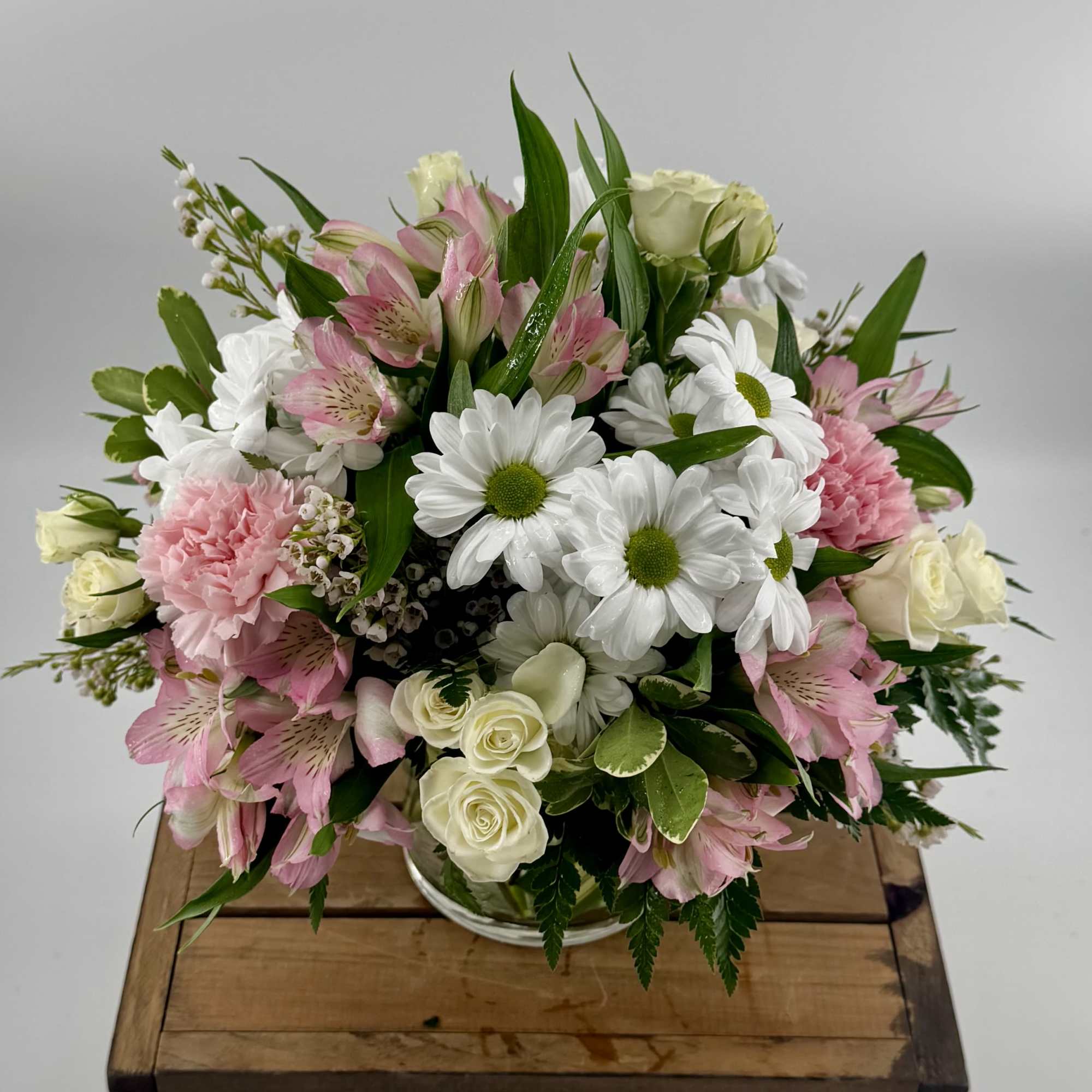 Brighten any moment with this exquisite arrangement of white daisies, soft pink