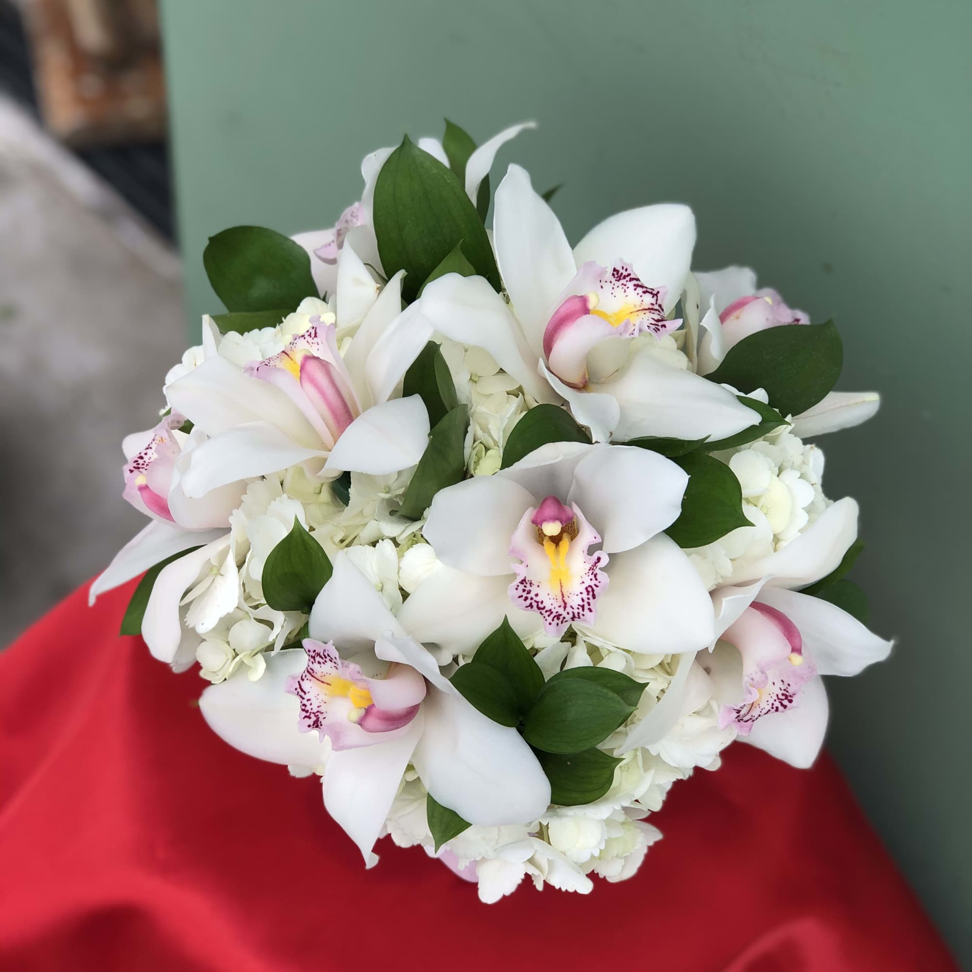 Orchids and Hydrangeas blended in a white vase to fit any decor