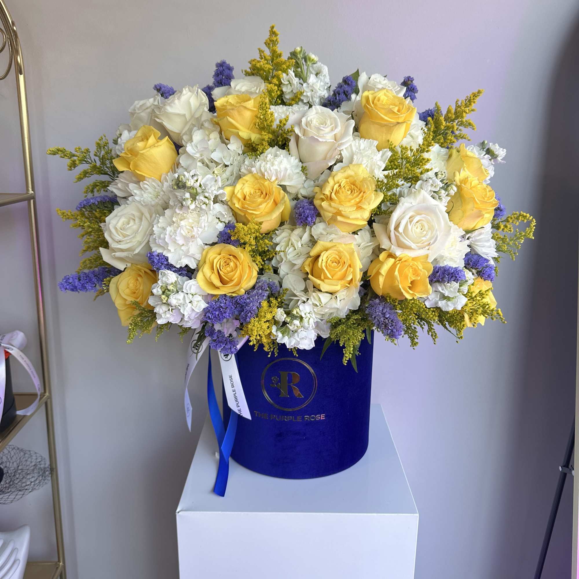 A radiant mix of yellow and white roses with purple accents, elegantly