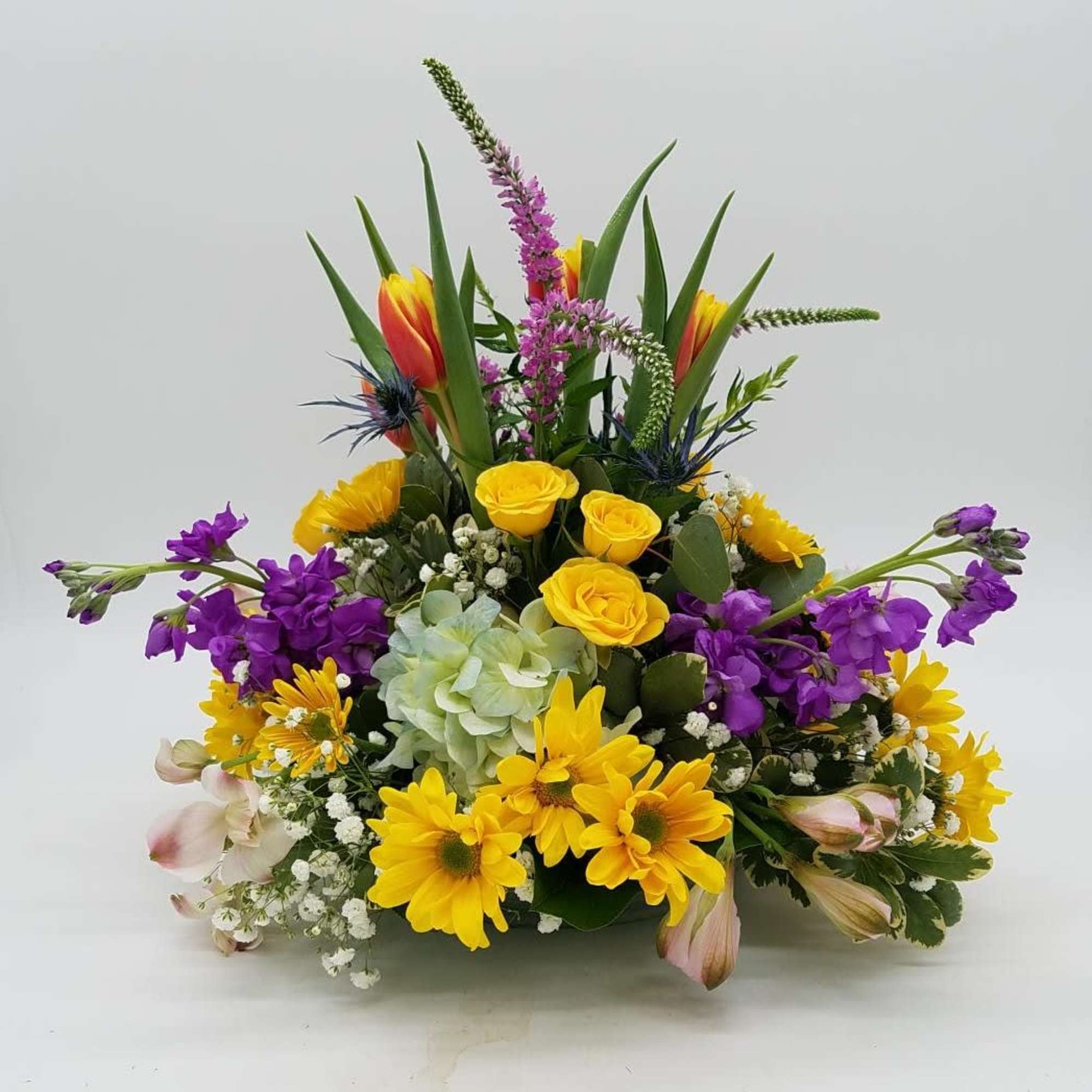 A beautiful mix of spring blooms, arranged round and low for the