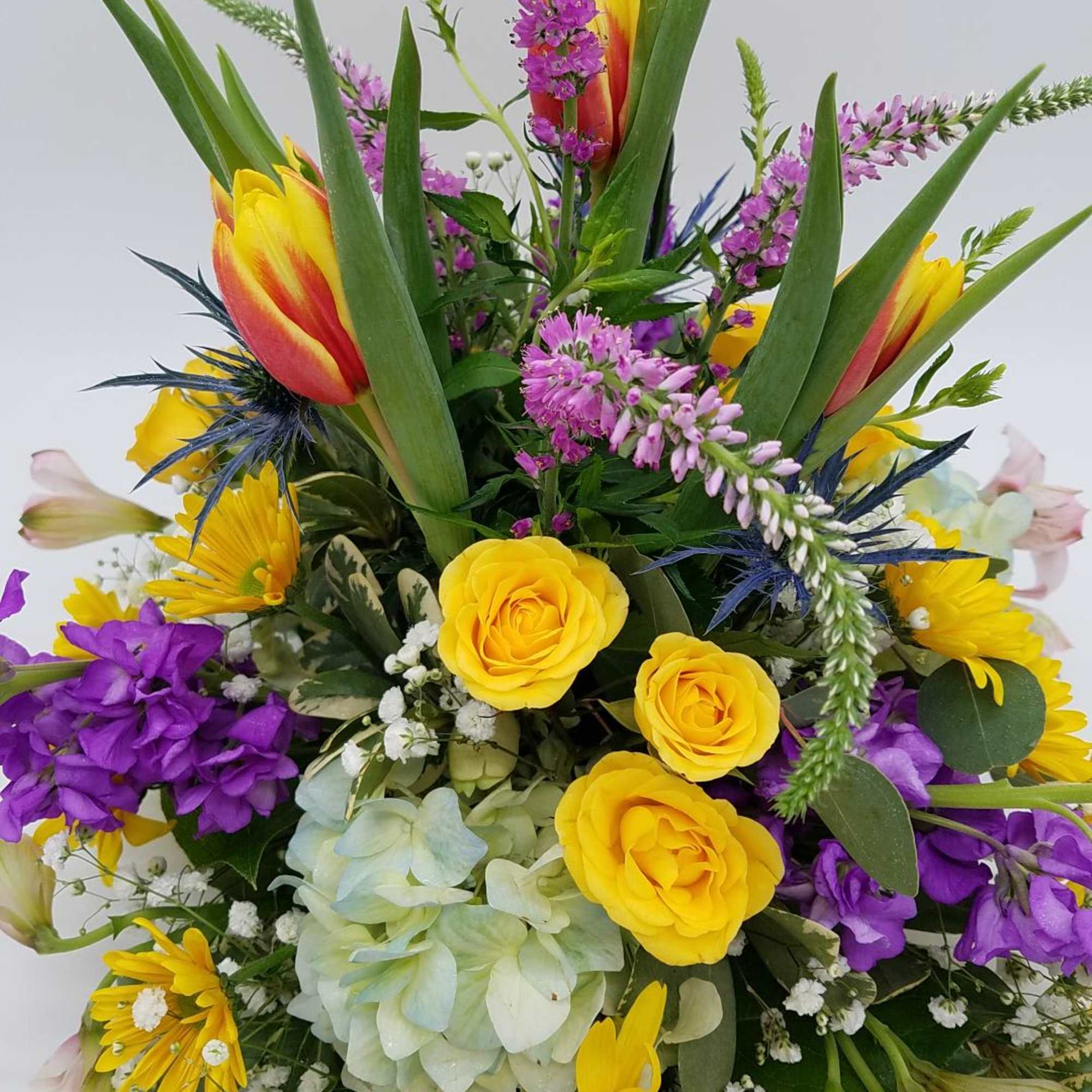 A beautiful mix of spring blooms, arranged round and low for the