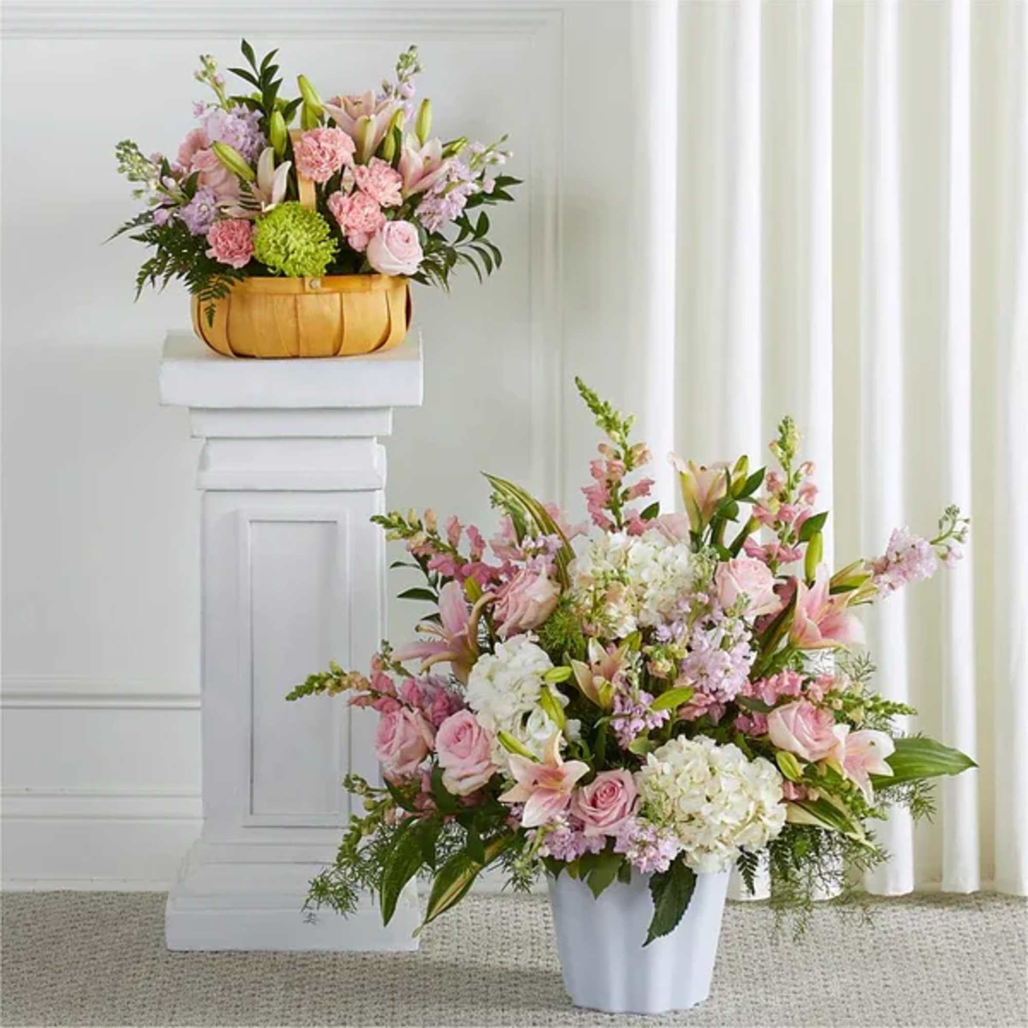 Pair of pastel pink and white floral arrangements in a wood basket and white container