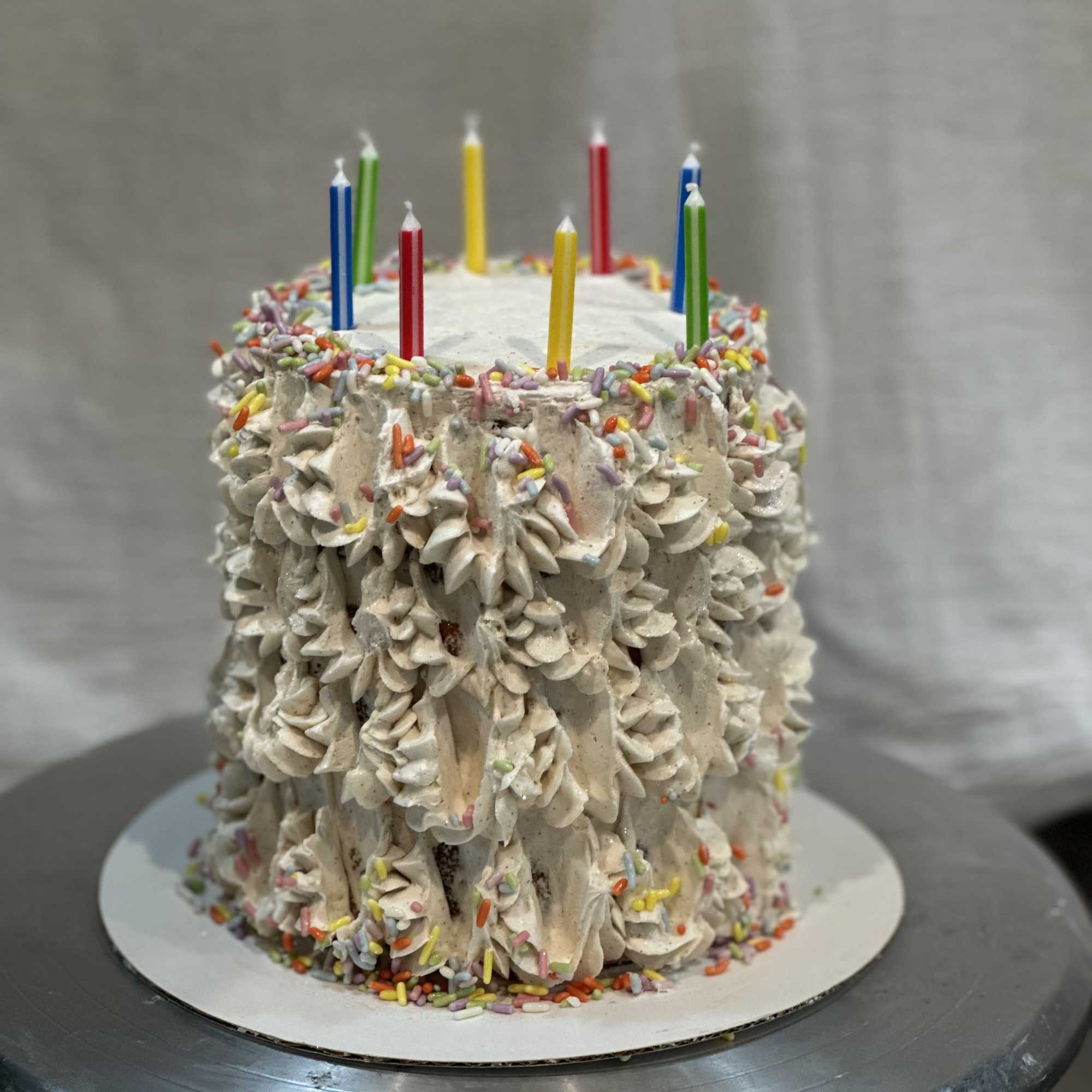 Decorated birthday cake with sprinkles and colorful candles