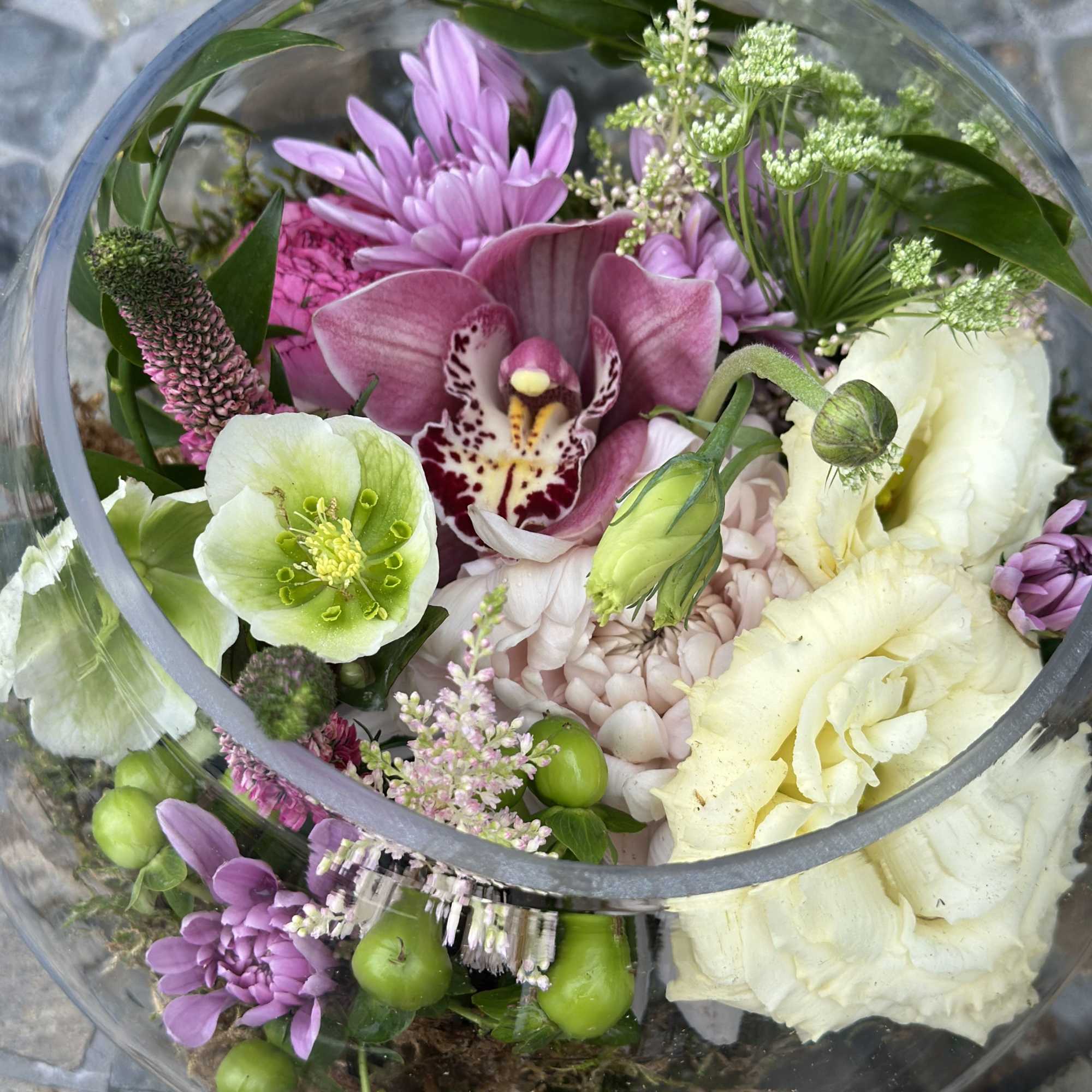 Tucked inside a modern glass container, "The Secret Garden" is a whimsical