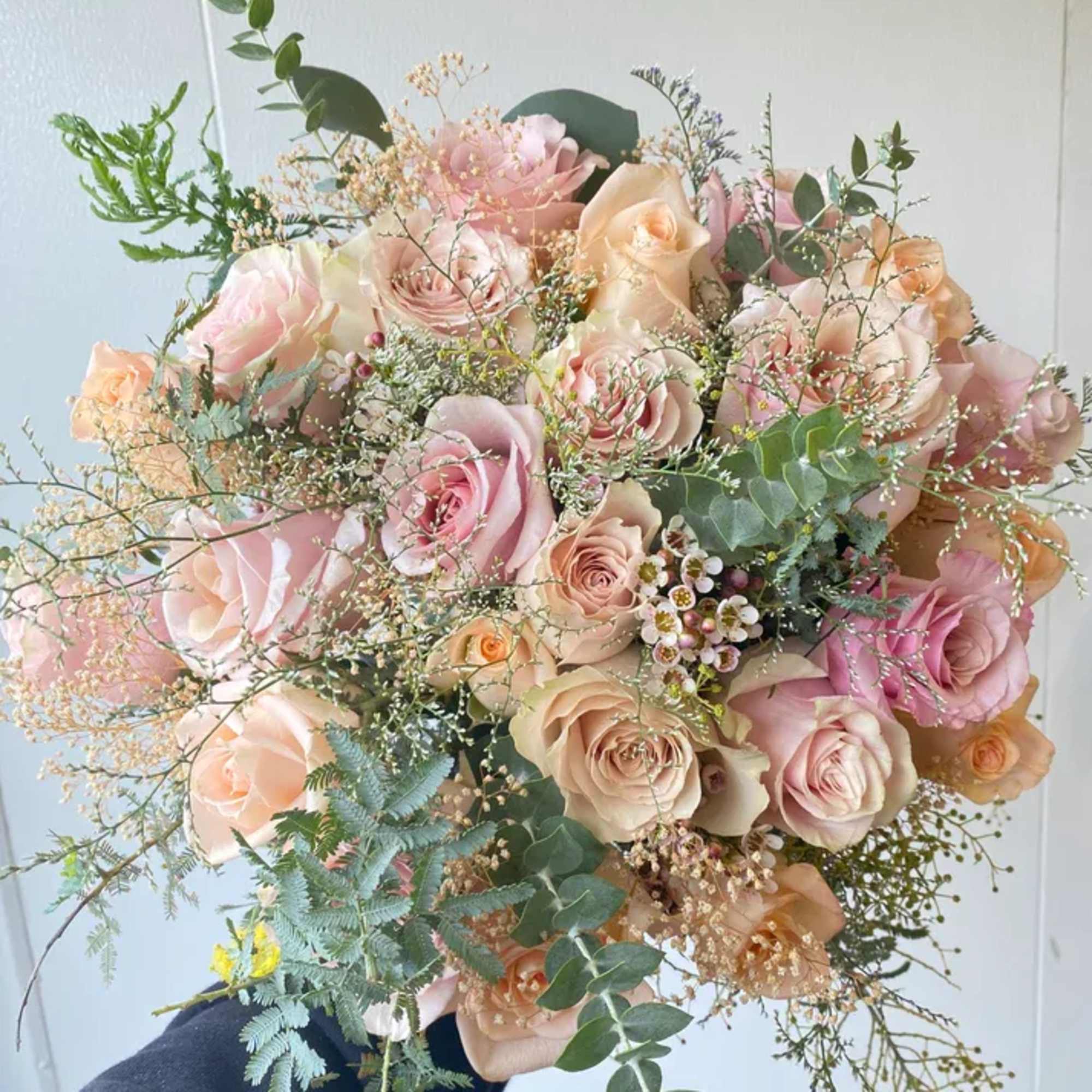 A soft, timeless mix of blush, tan, cream, and peach-toned roses, accented