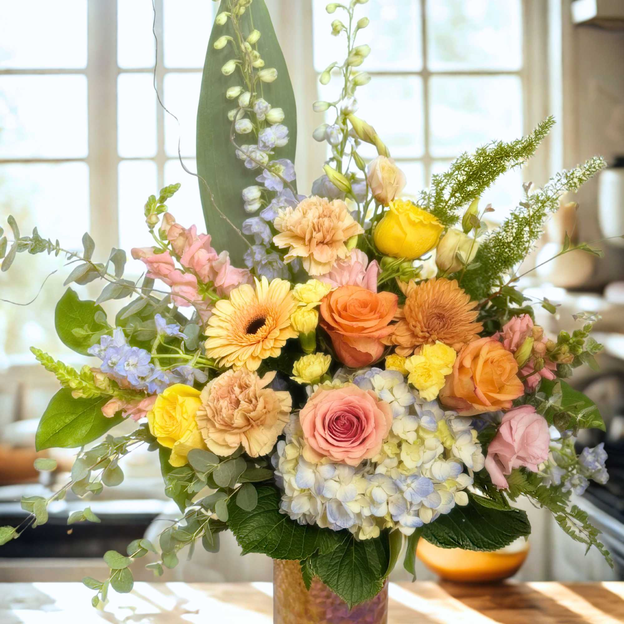 Mixed pastel flower arrangement in a glass vase
