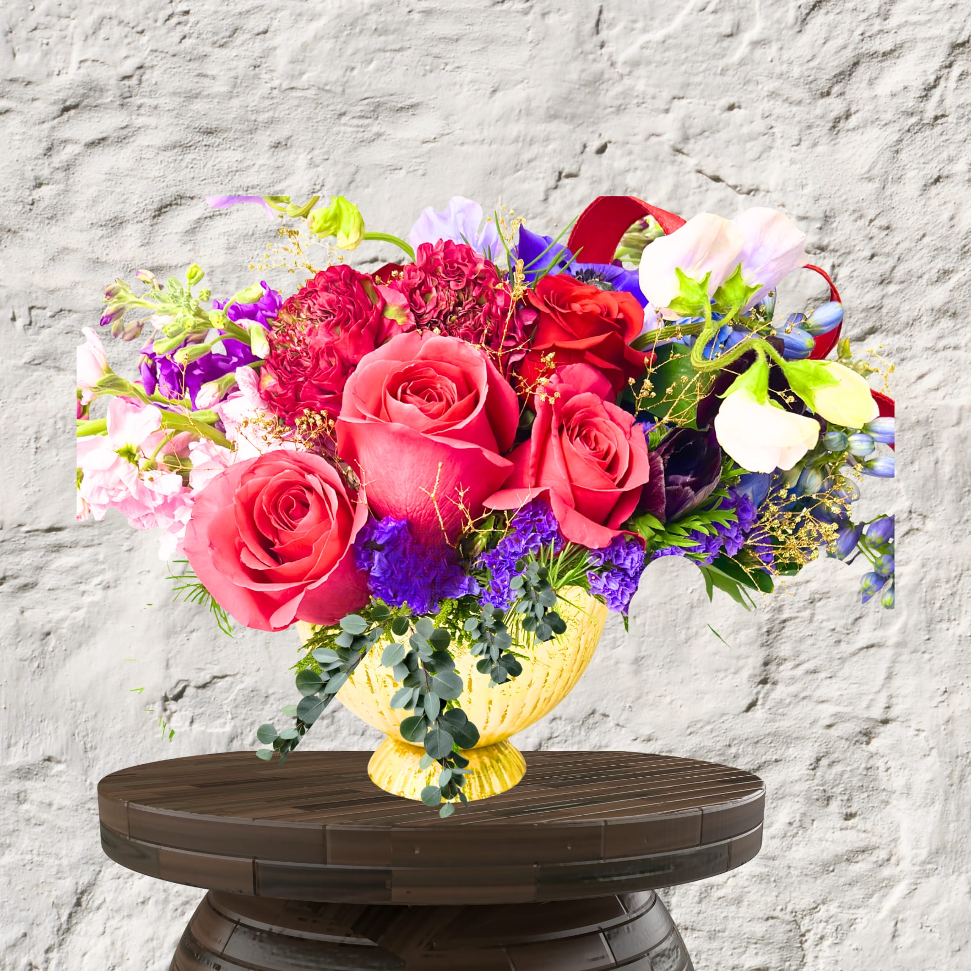 Bright mixed bouquet of roses and sweet peas in a yellow vase