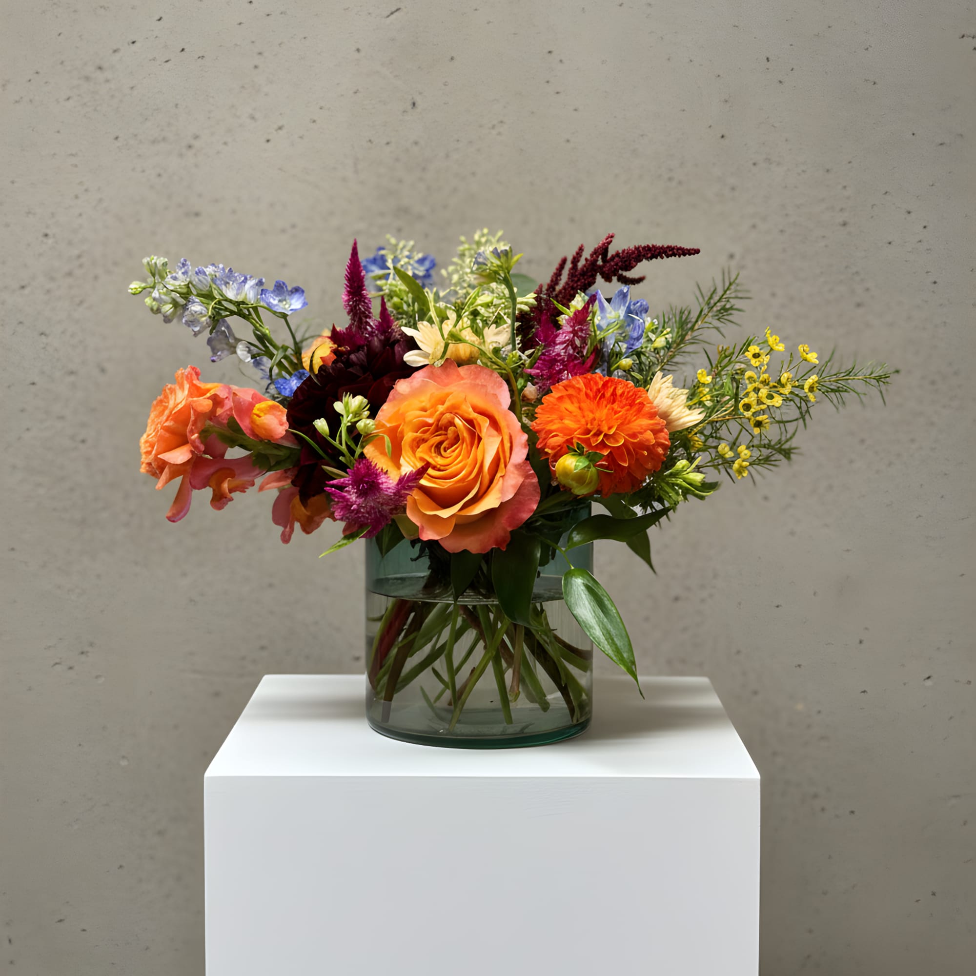 Mixed bouquet in a glass vase with orange, purple, and yellow flowers