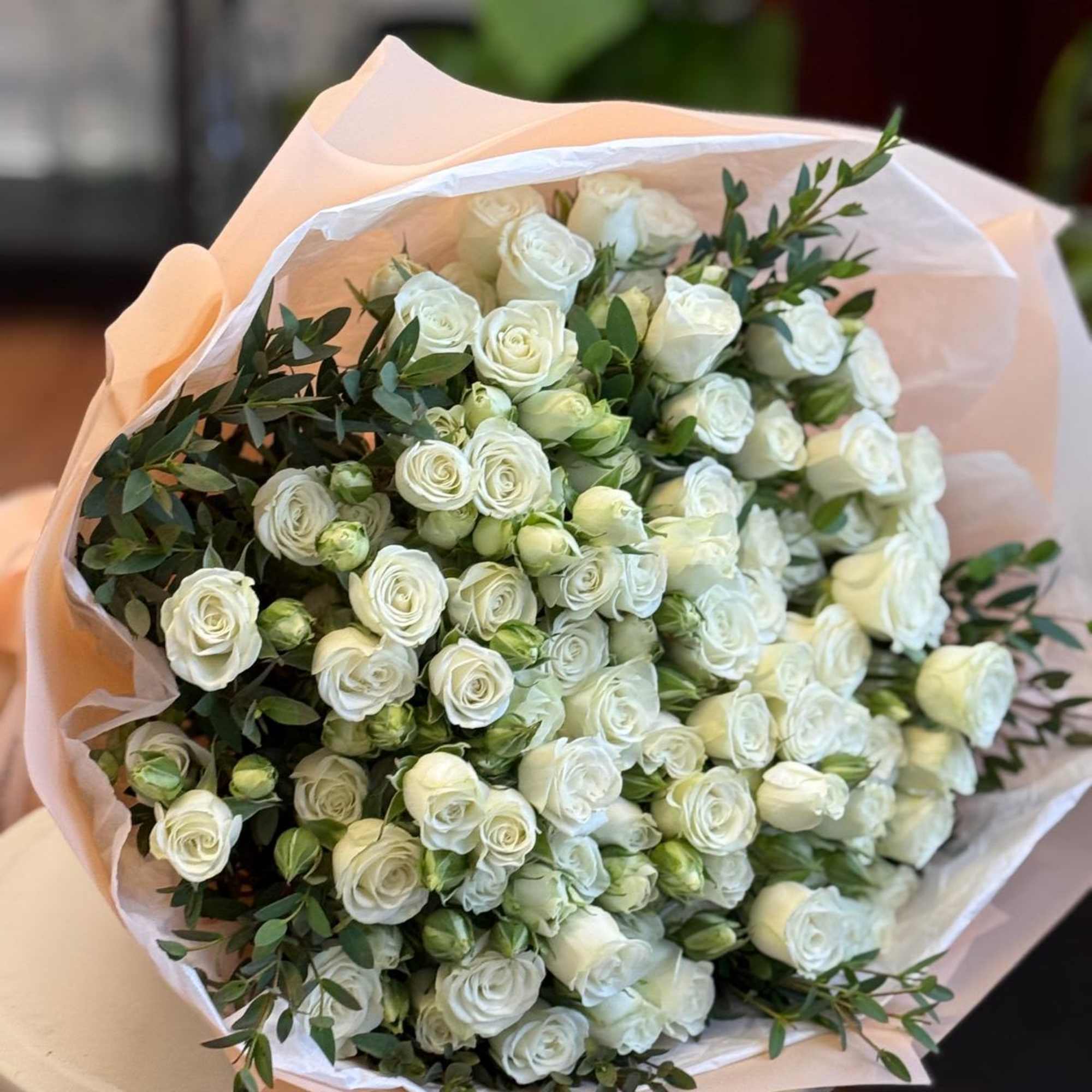 This is a breathtaking medium-size bouquet of spray white roses and greenery