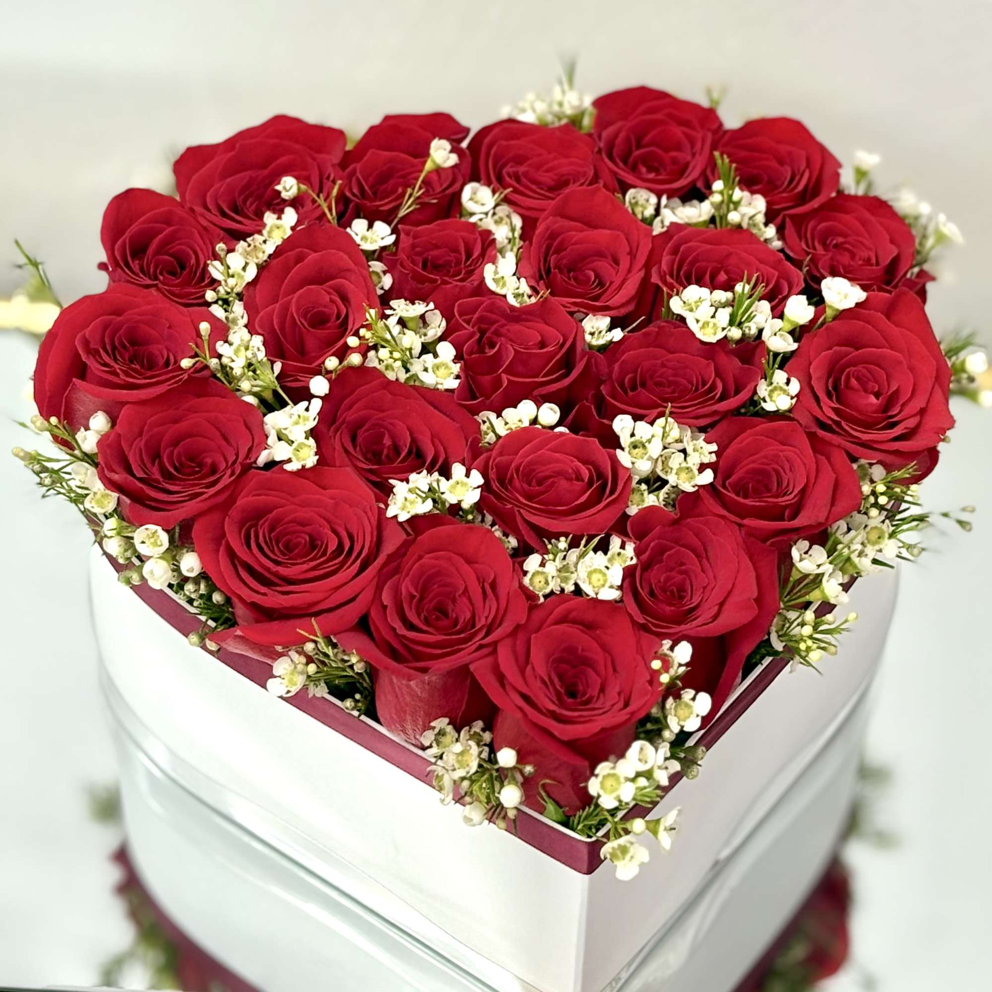 A heart with red roses and wax flowers is a sign of