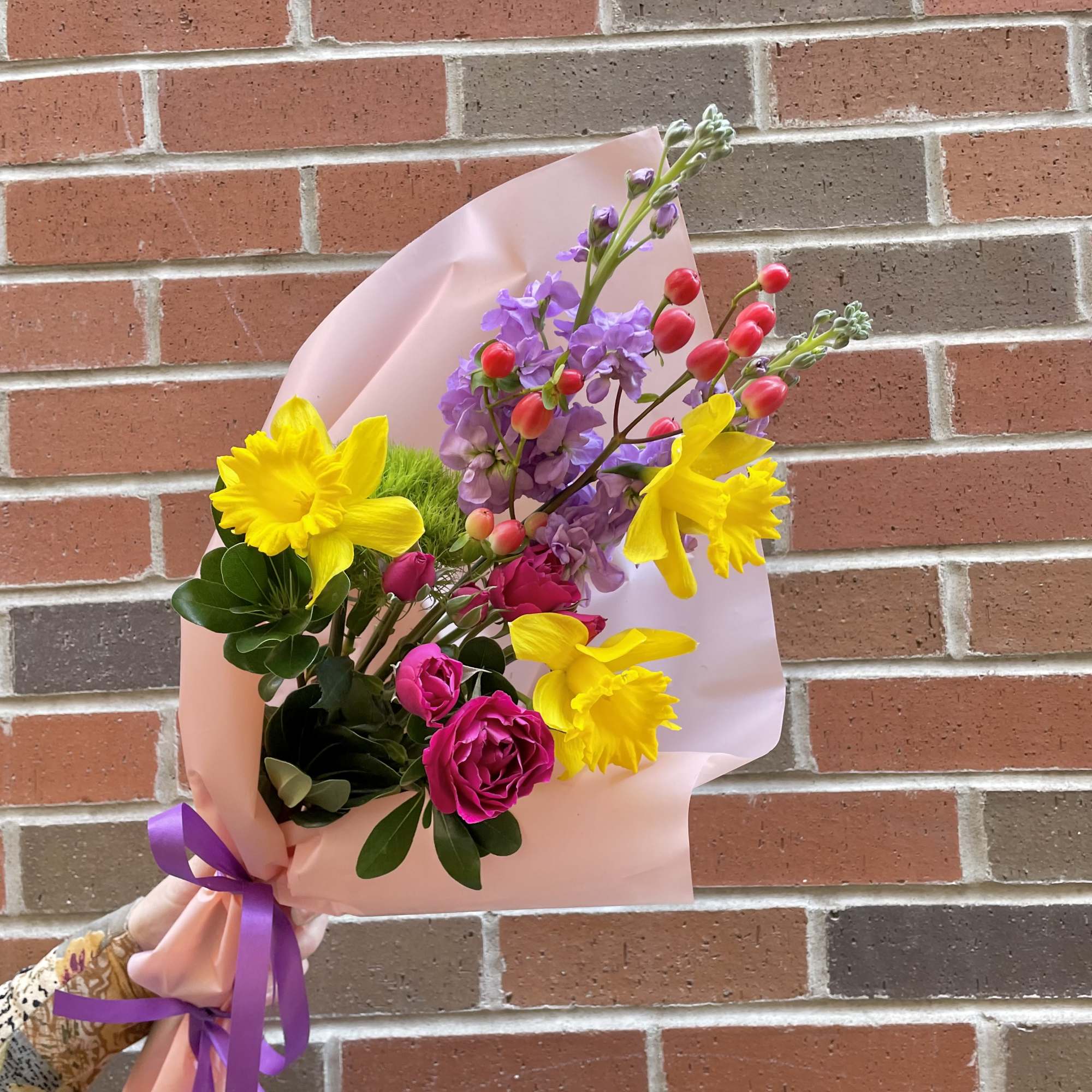 'Into The Hills' is a wrap bouquet of Daffodils, Stock, spray Roses