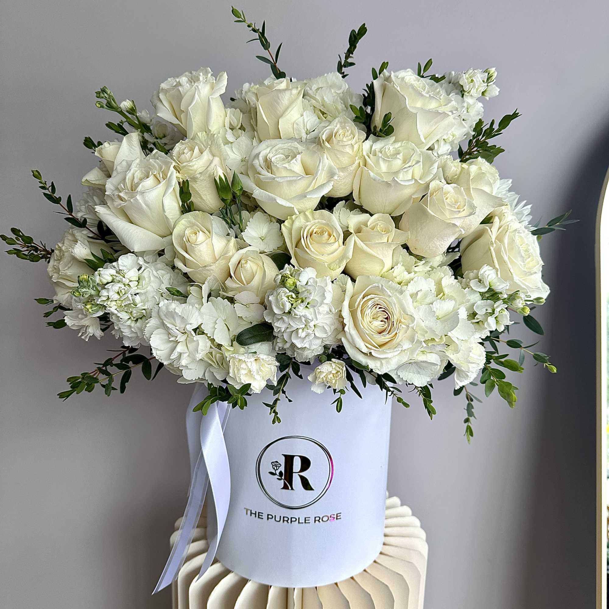 This stunning floral arrangement showcases a luxurious blend of fresh white