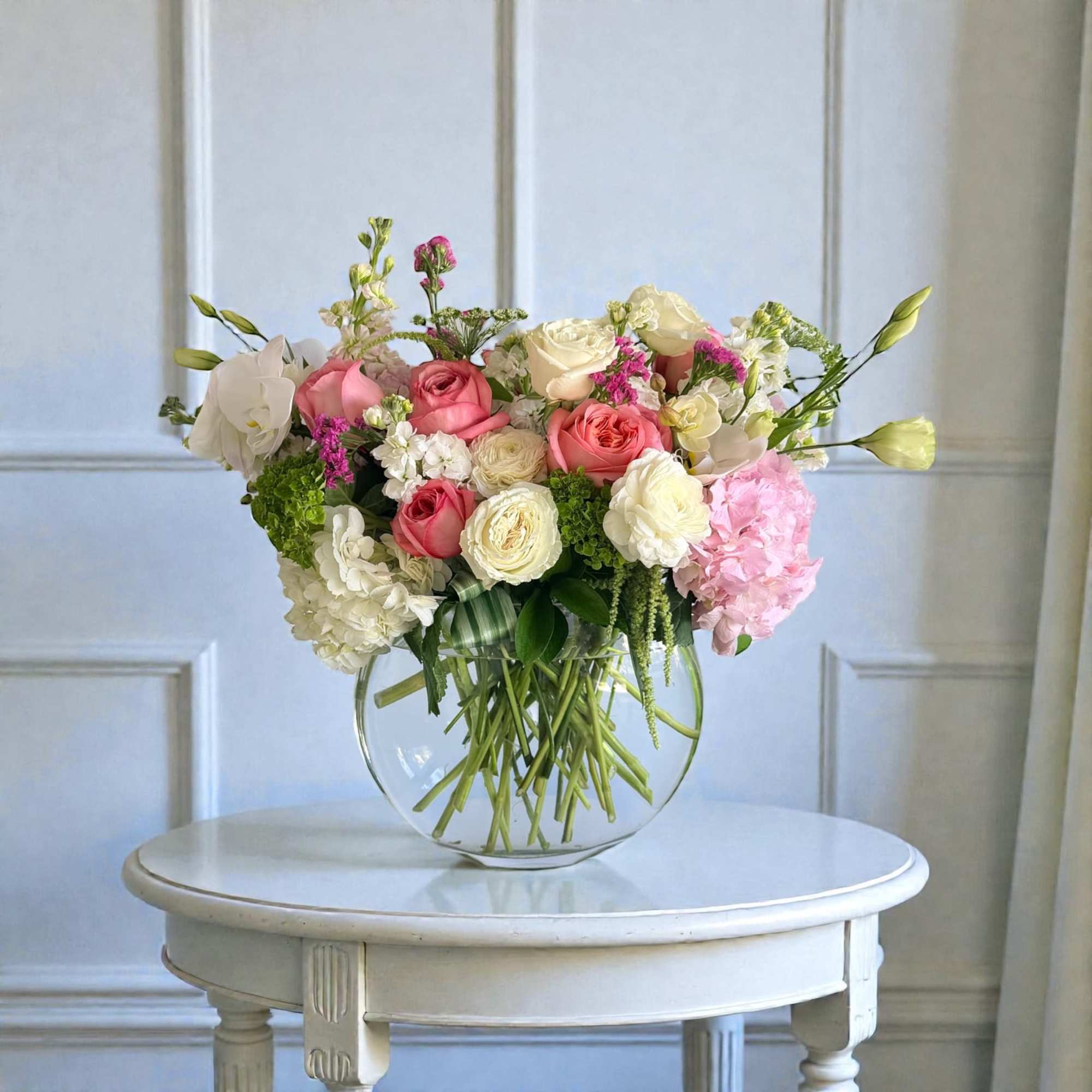 Pink and white flower arrangement in a clear glass vase