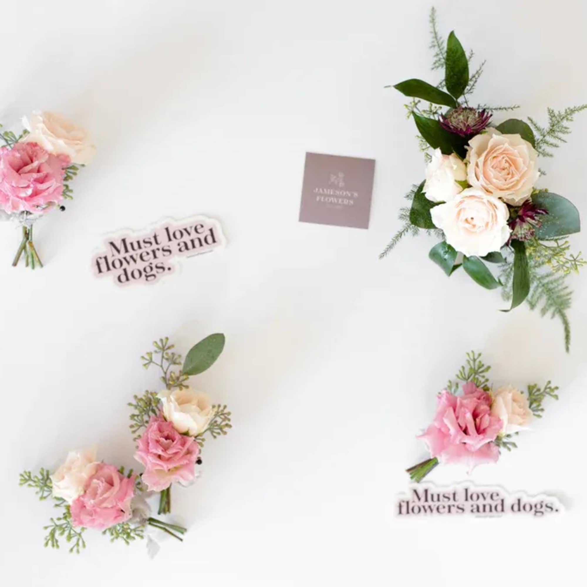 Small pink and cream rose bouquets with greenery on a white background