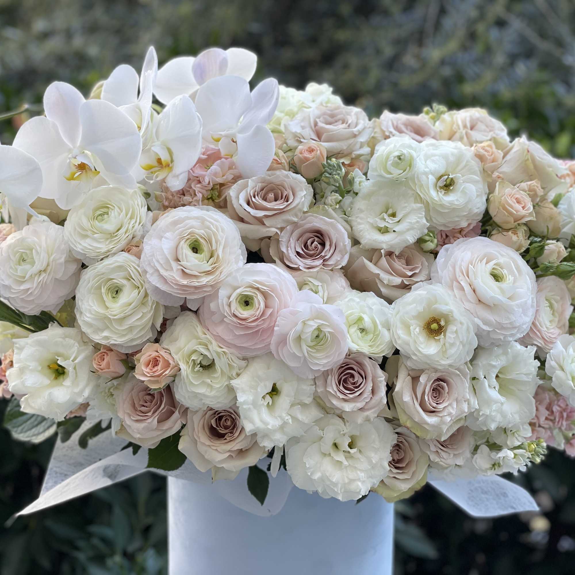 Charming and tender ranuncules and roses in a soft blue velvet box