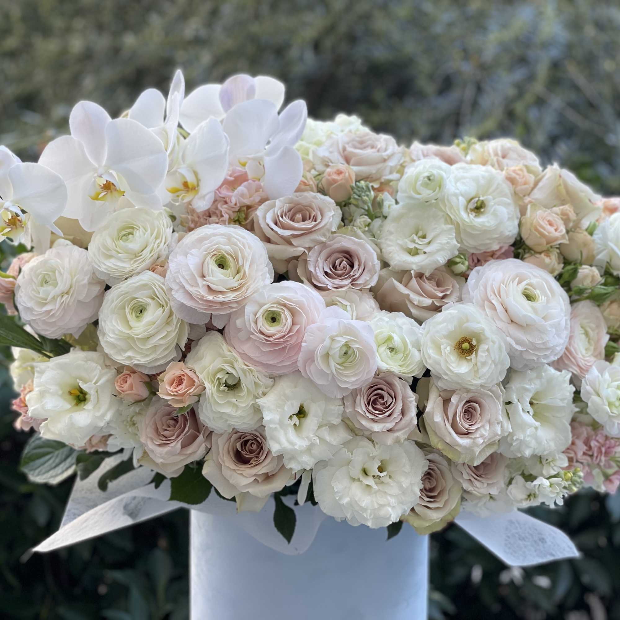 Charming and tender ranuncules and roses in a soft blue velvet box