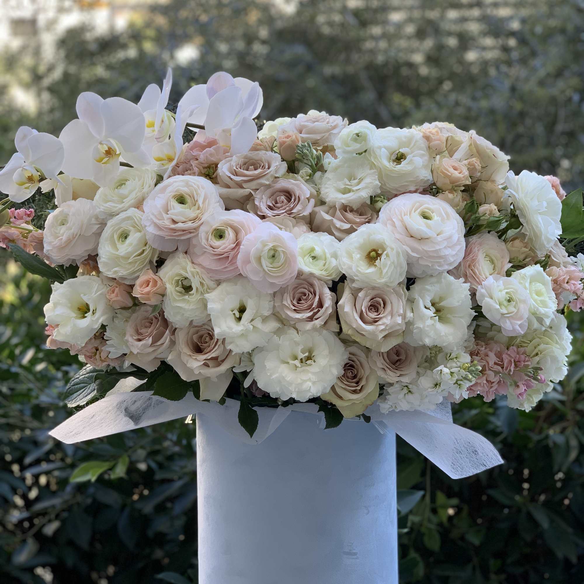 Charming and tender ranuncules and roses in a soft blue velvet box