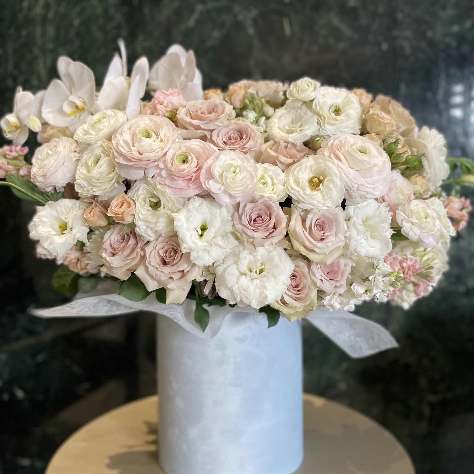 Charming and tender ranuncules and roses in a soft blue velvet box