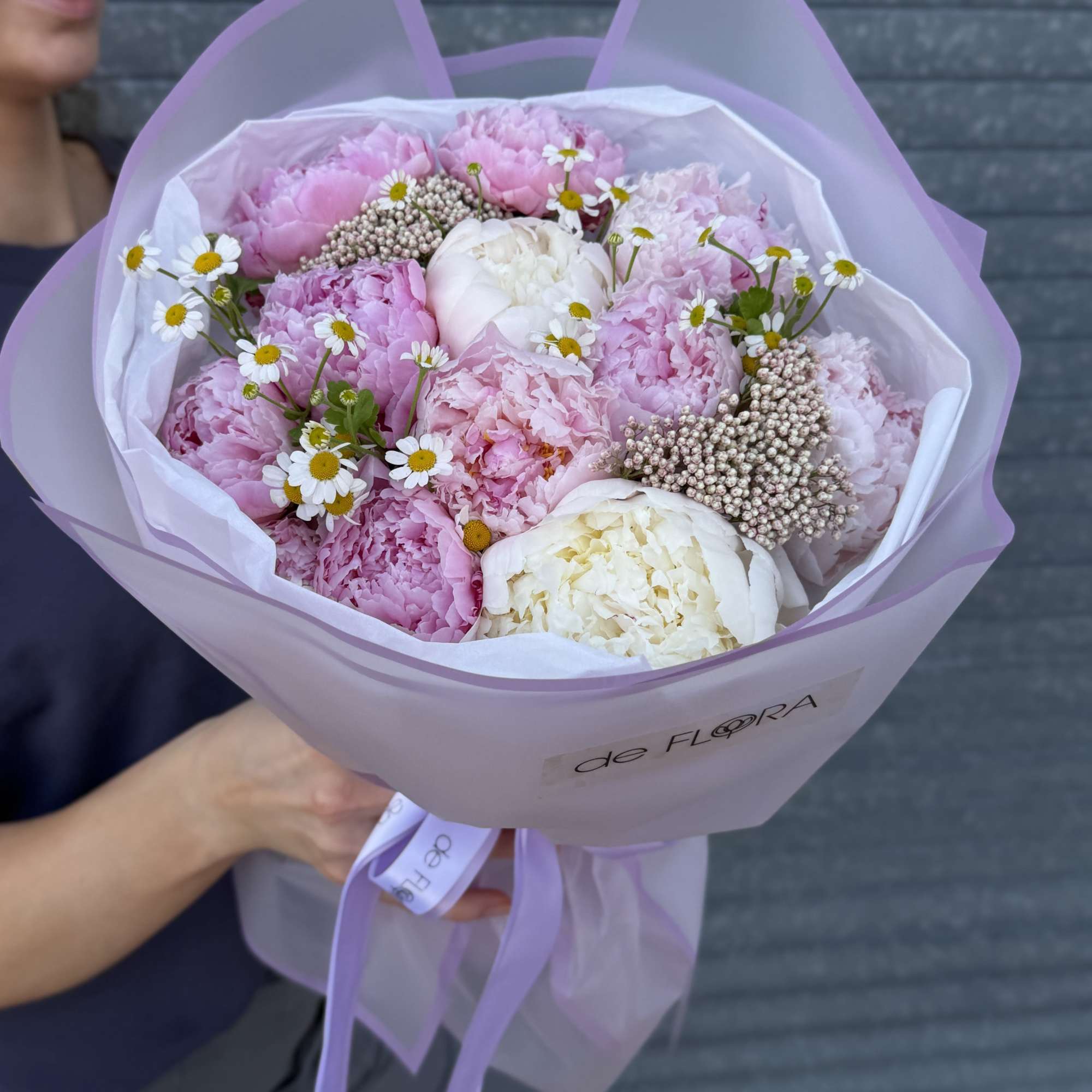 Pink peonies and white blooms in a lavender-wrapped bouquet