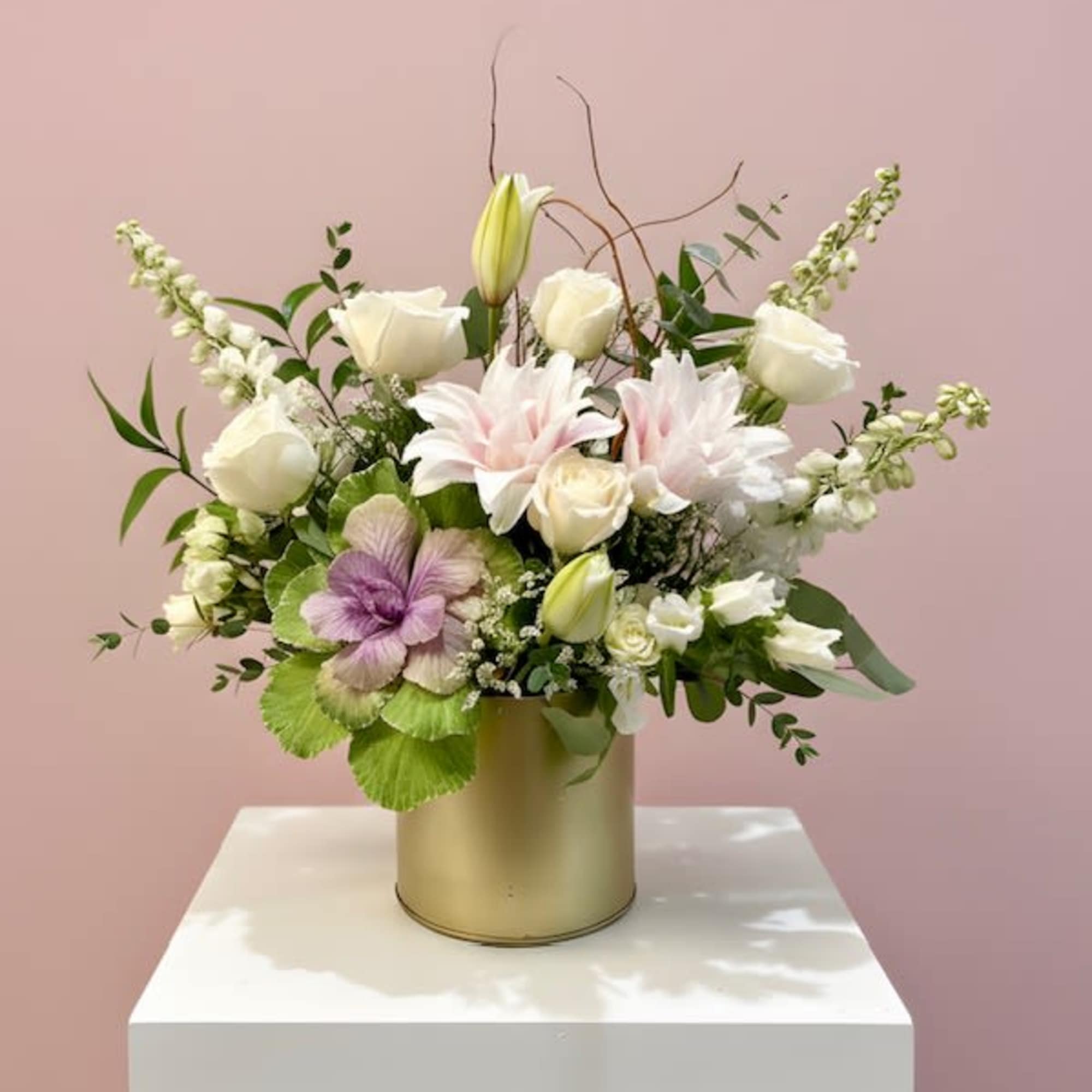 An elegant white and green arrangement featuring textured kale, white roses, delphinium