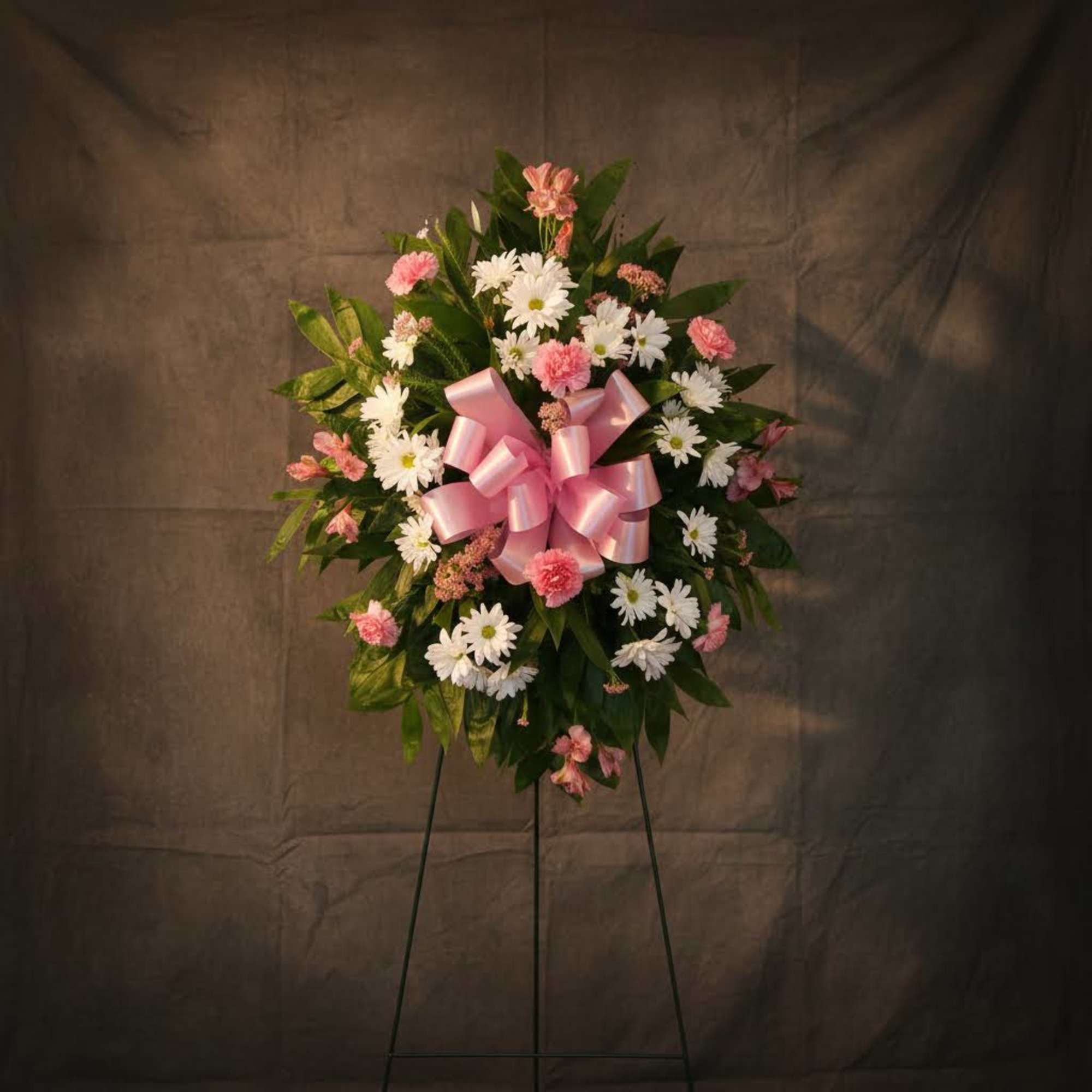 Pink and white floral standing wreath with a pink ribbon bow