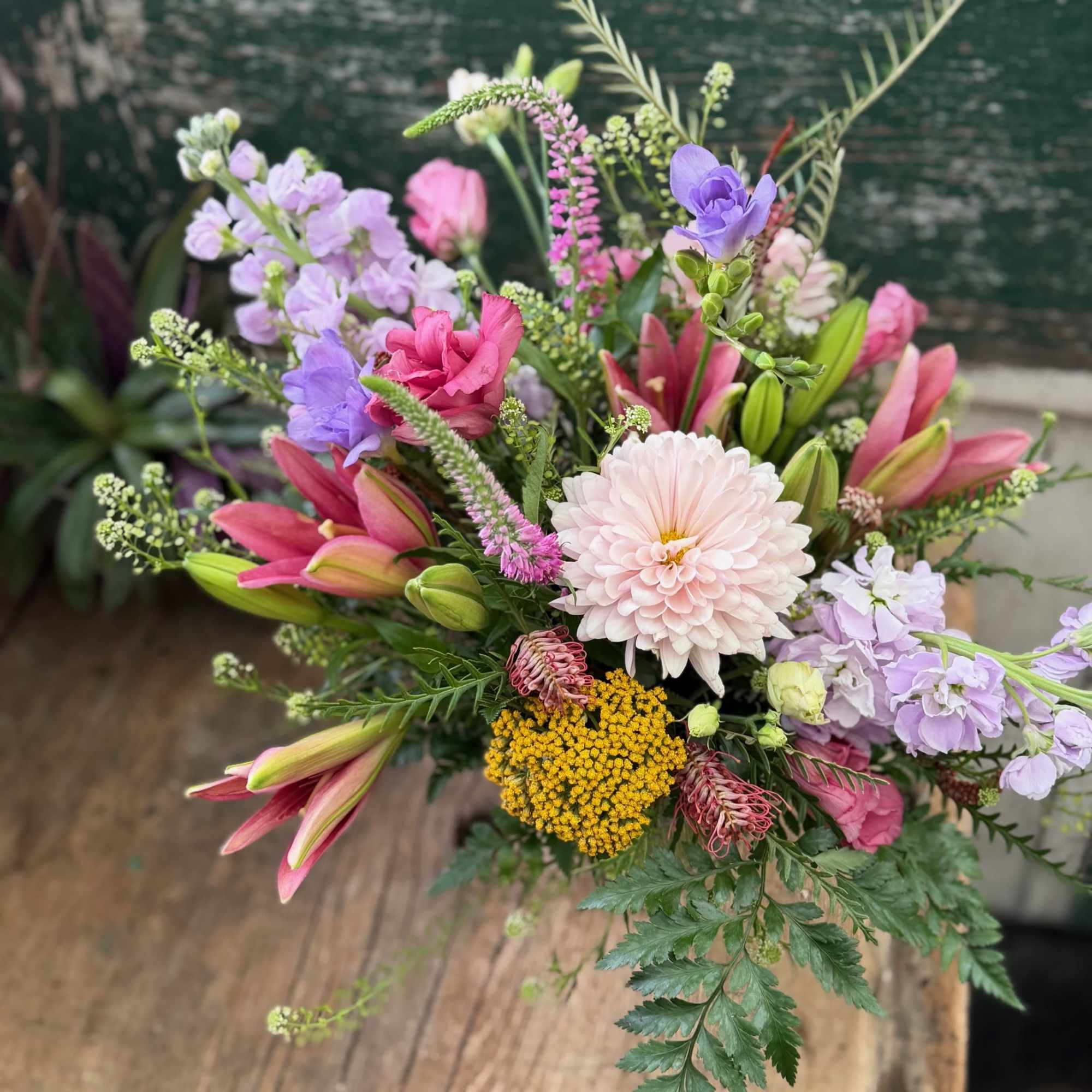 Mixed bouquet with pink lilies, lavender blooms, and a pale dahlia