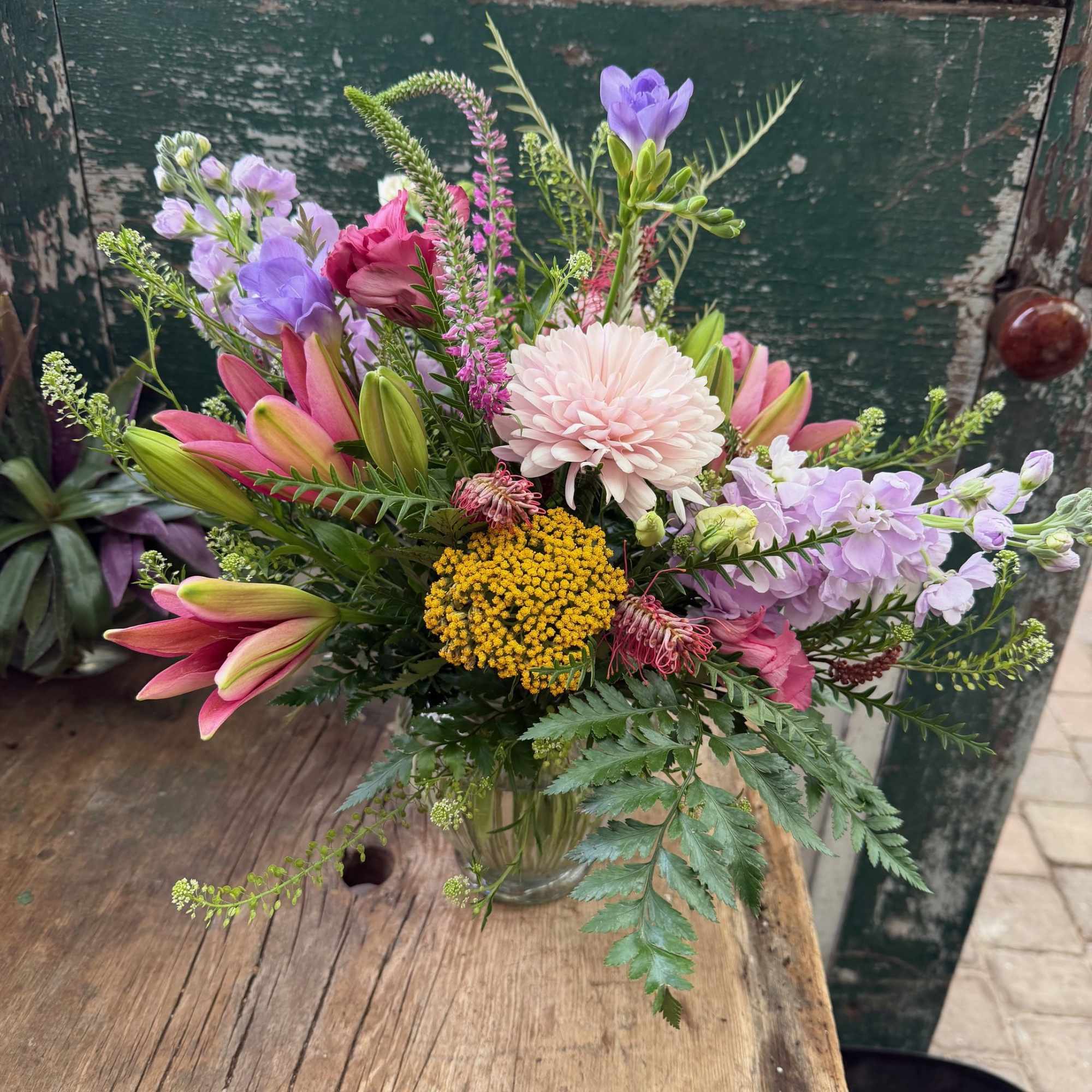 Mixed bouquet in a glass vase with pink, purple, and white blooms
