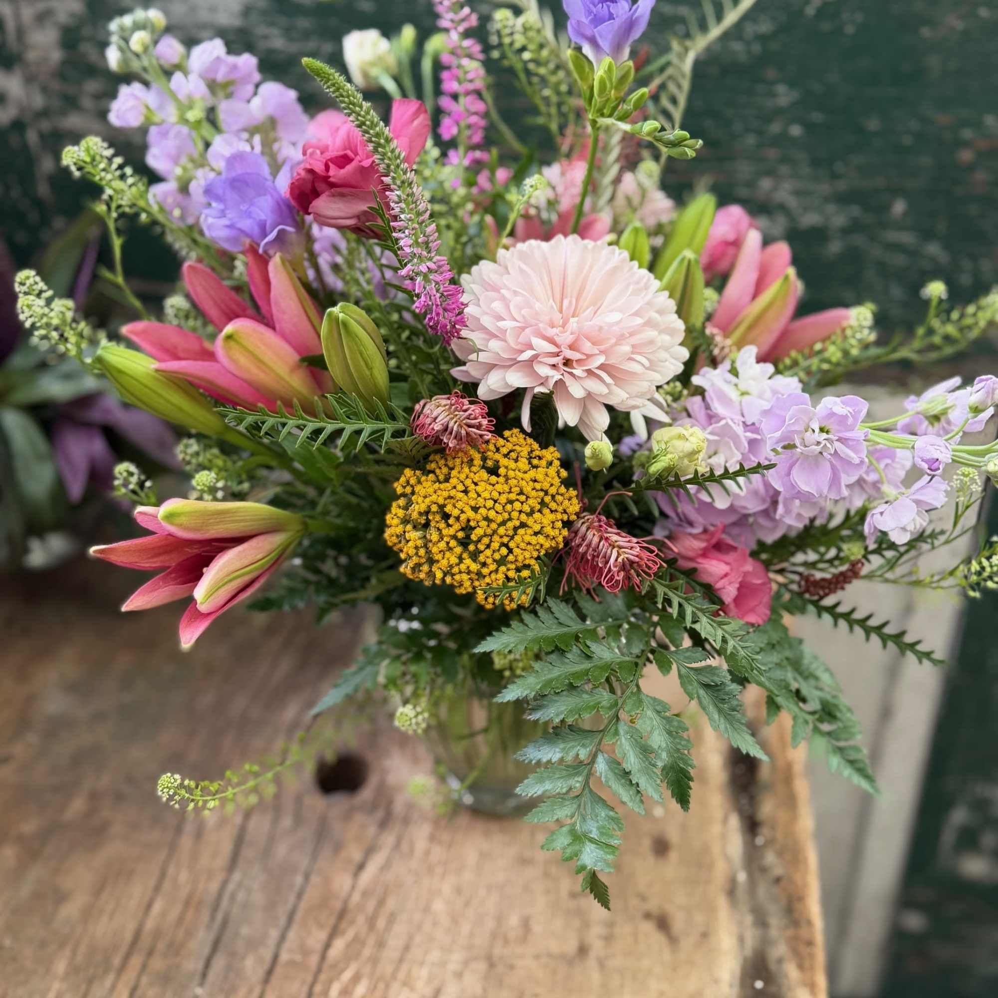 Mixed bouquet with pink lilies, lavender blooms, and a pale pink chrysanthemum