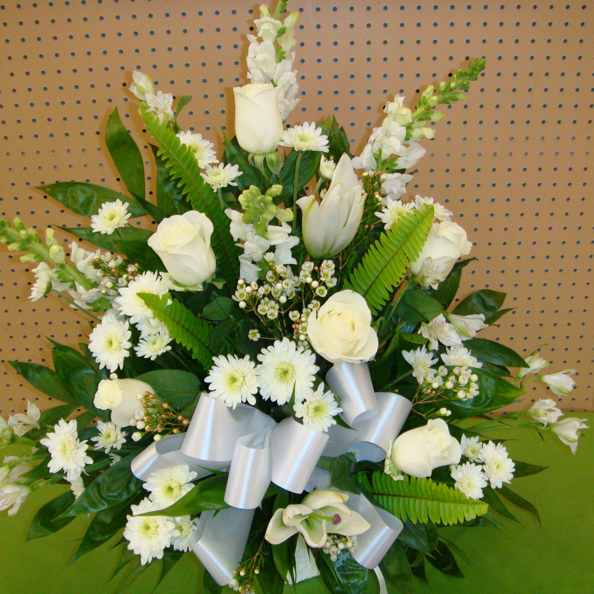 White rose and daisy arrangement with a silver ribbon