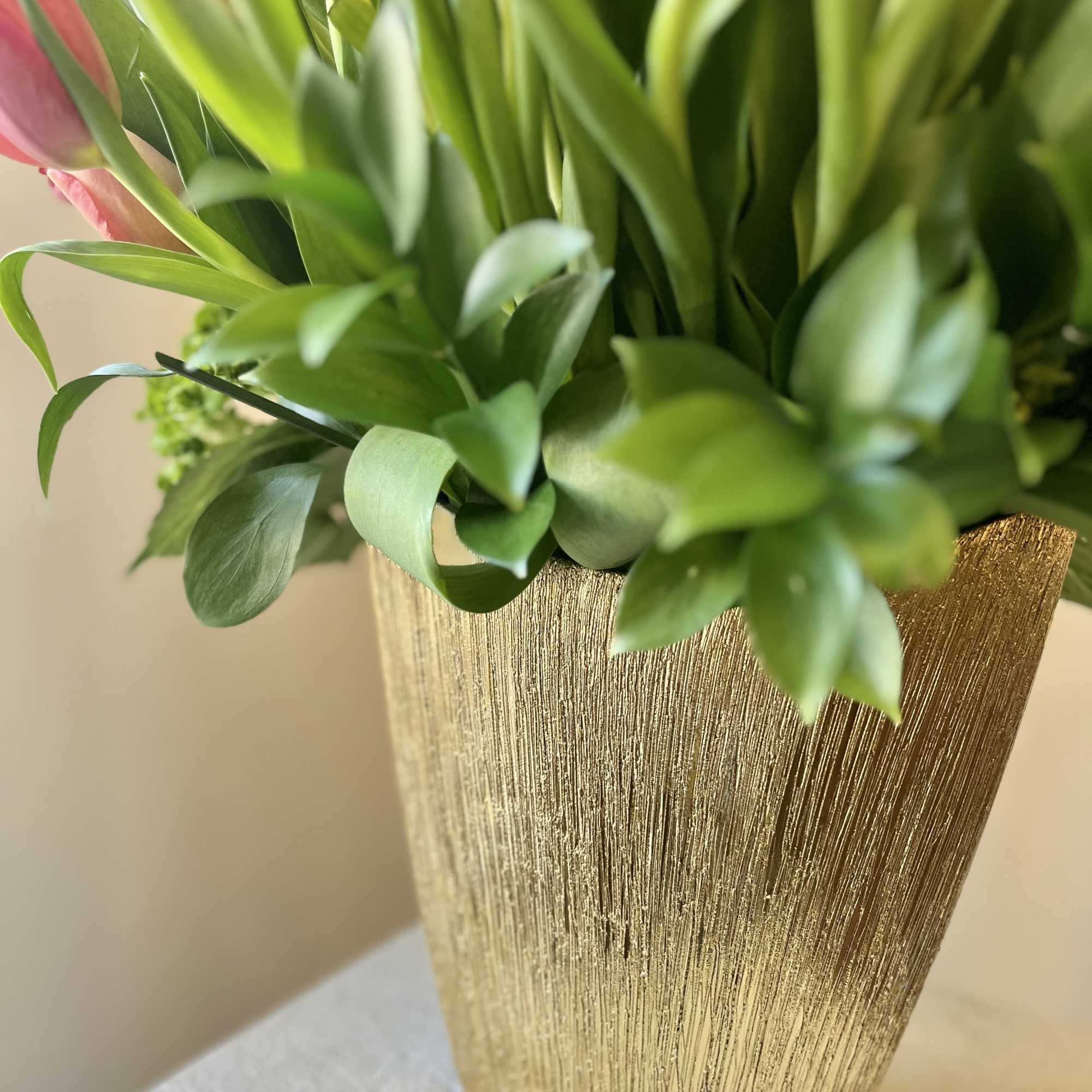 Pink tulips in a gold textured vase