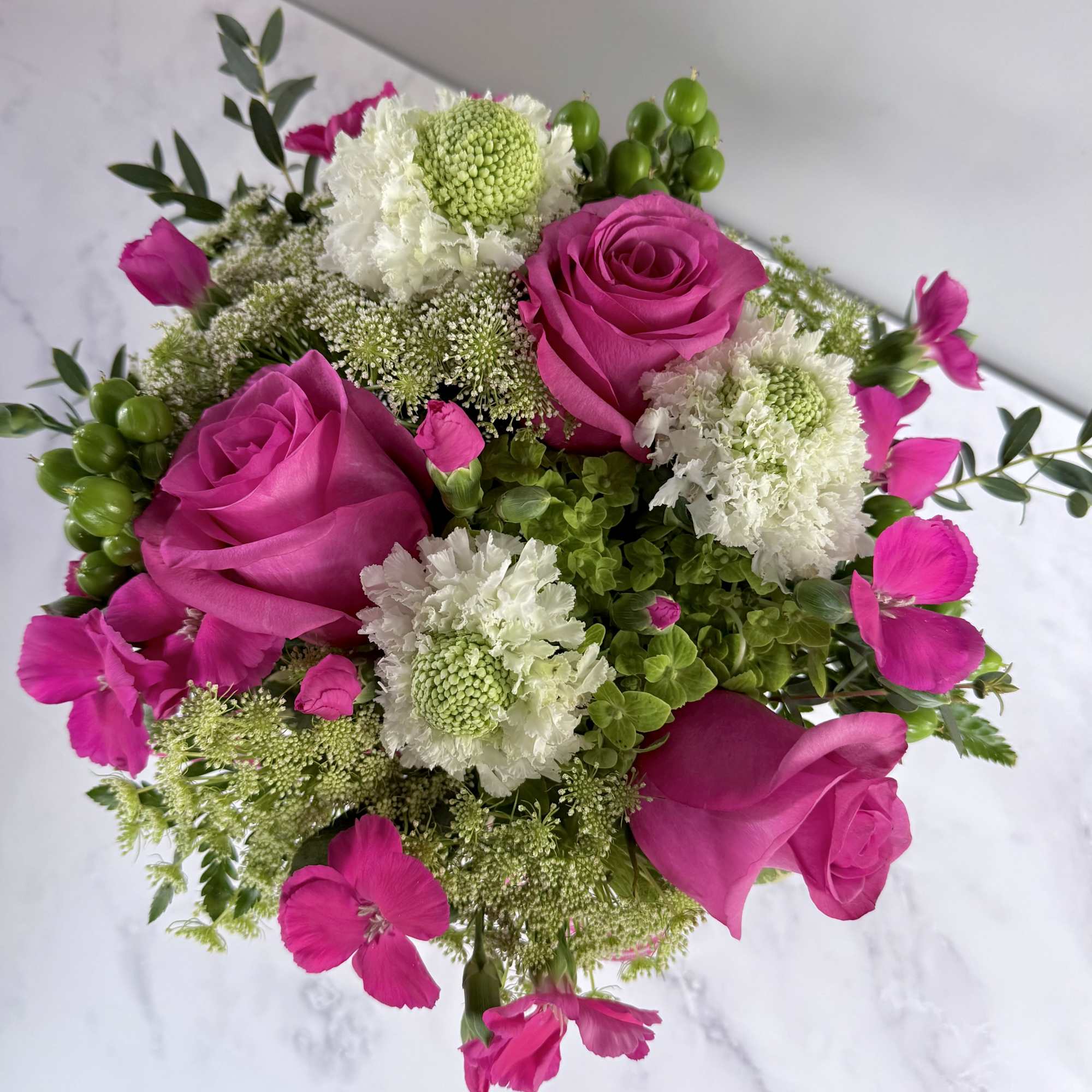 A 5&rdquo; by 5&rdquo; cube filled with a green hydrangea, queen Anne&rsquo;s