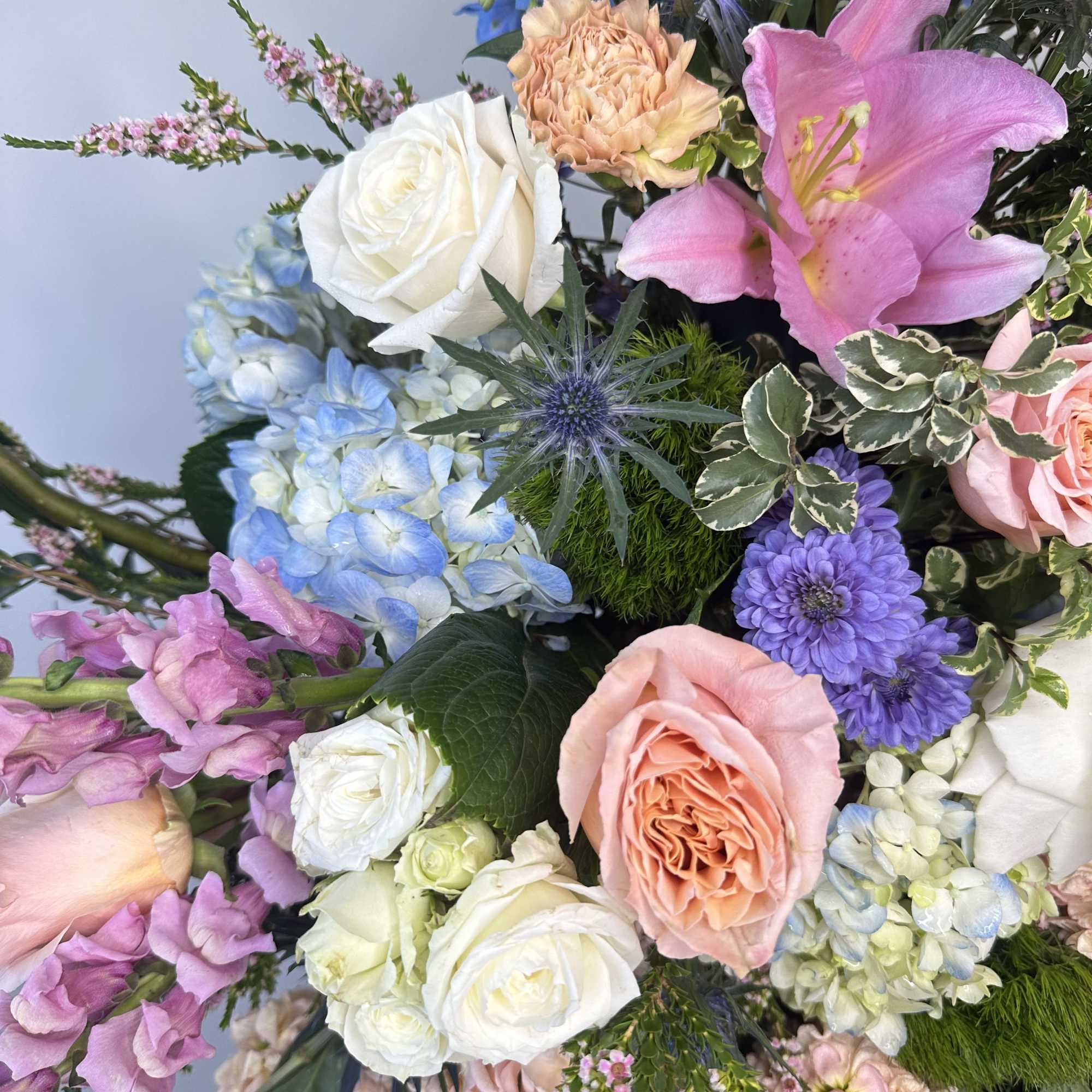 Mixed bouquet with pink lilies, roses, hydrangeas, and purple blooms