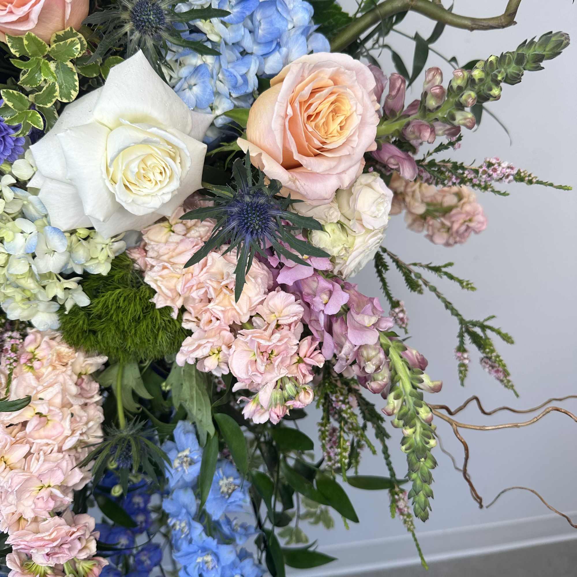 Bouquet of pastel roses, hydrangeas, and blue delphinium