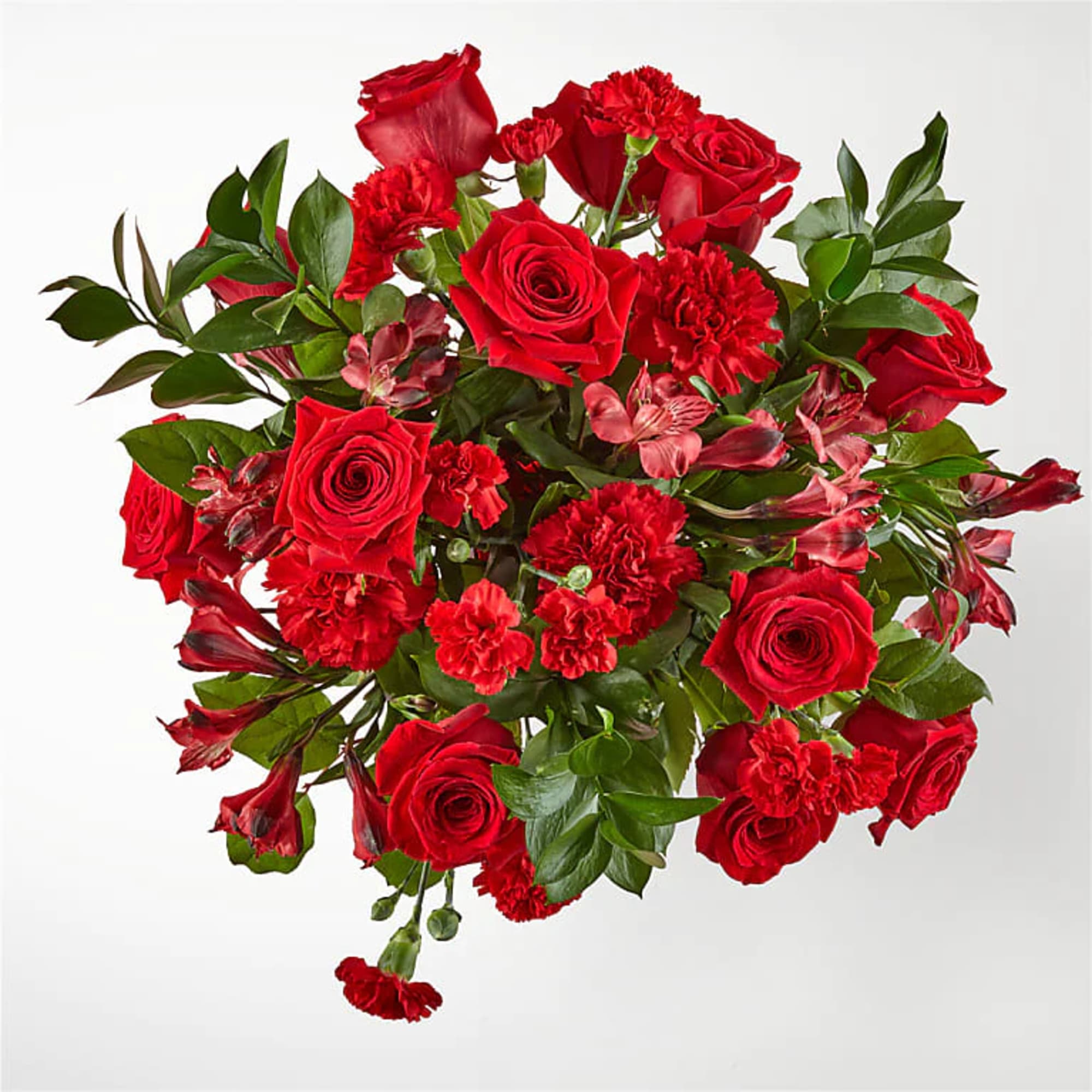
Amplified by a ruby red vase, this rich arrangement of roses, carnations