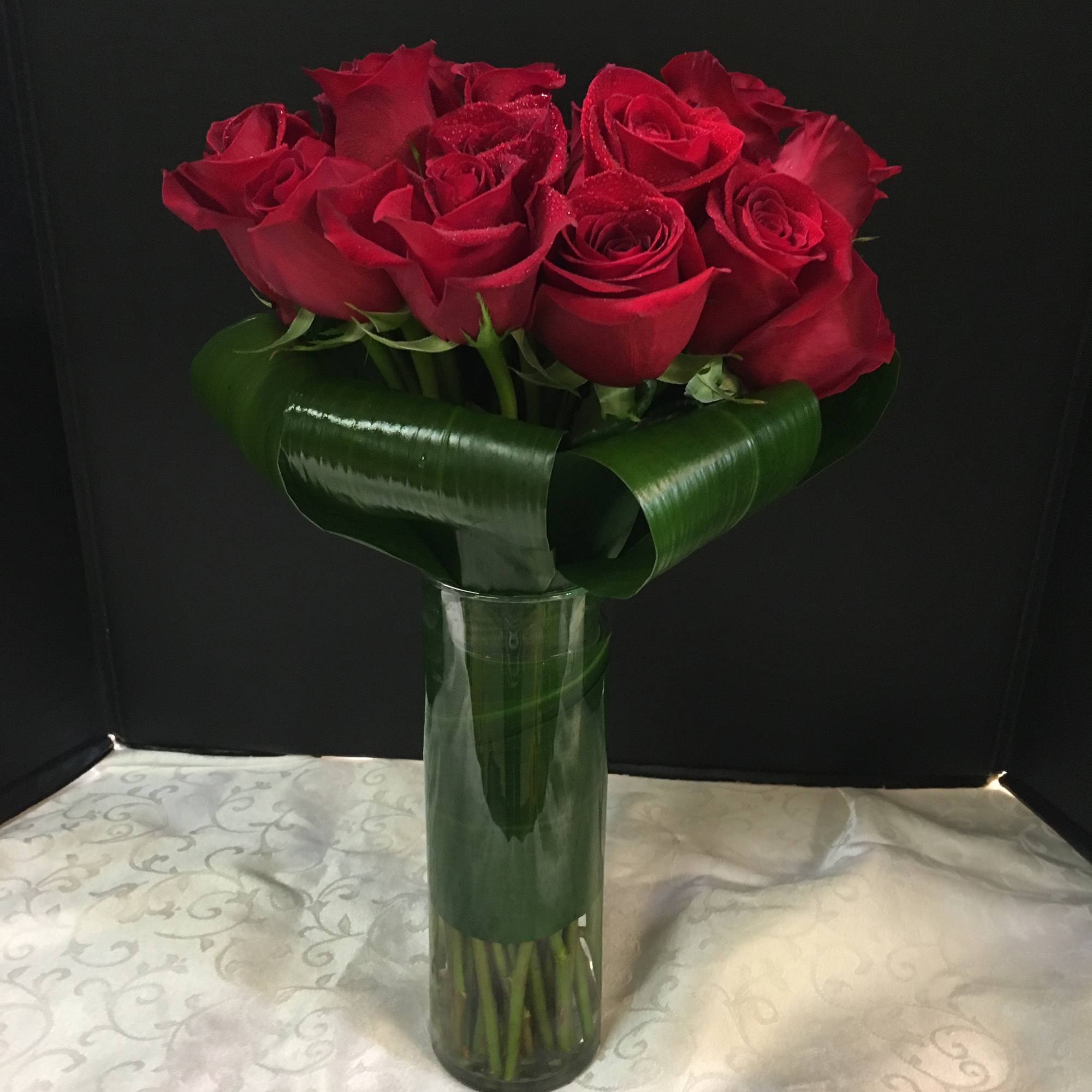  Long Stemmed Roses tightly arranged in a Cylinder vase..
Arrangement can be