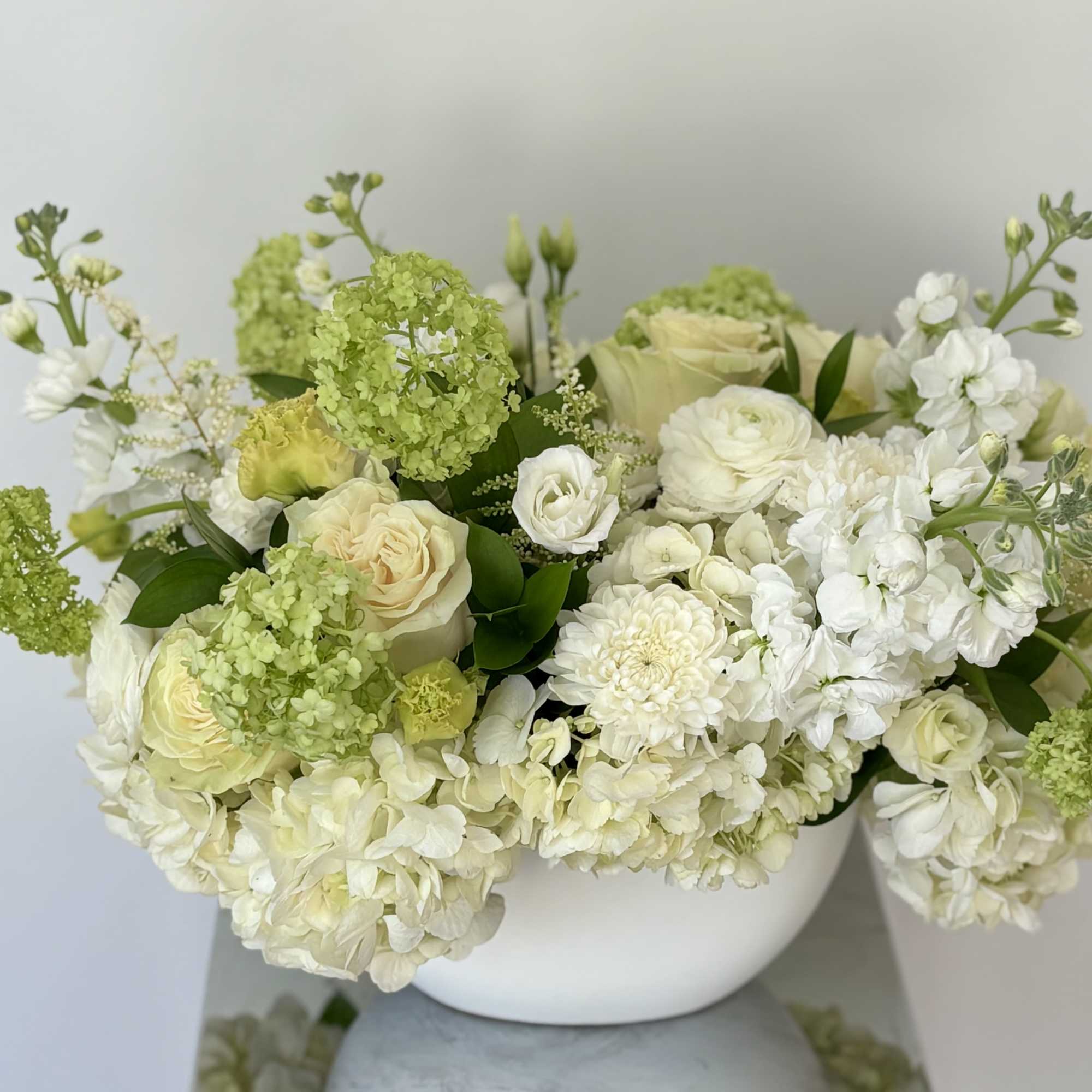 Neutral color tones in this elegant flower arrangement in a boat-shaped white